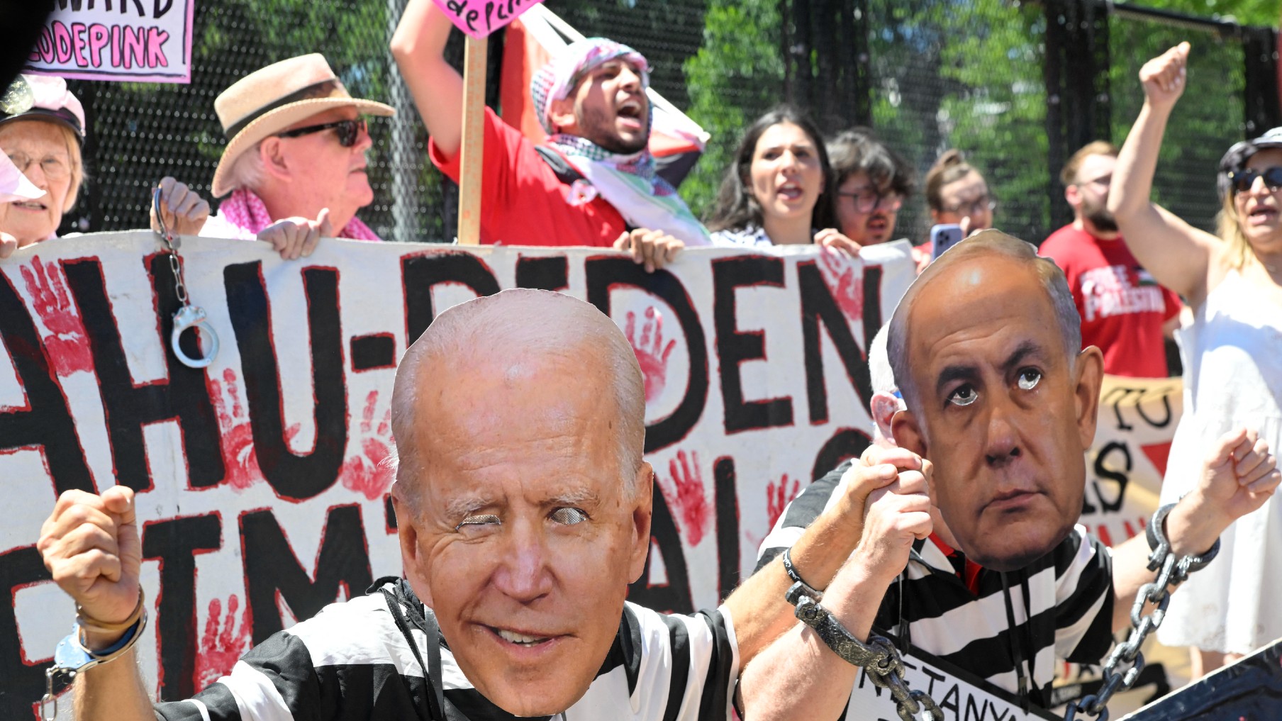  Pro-Palestinian activists wear masks depicting US President Joe Biden and Israeli Prime Minister Benjamin Netanyahu in front of the White House on 8 June, 2024 (AFP)