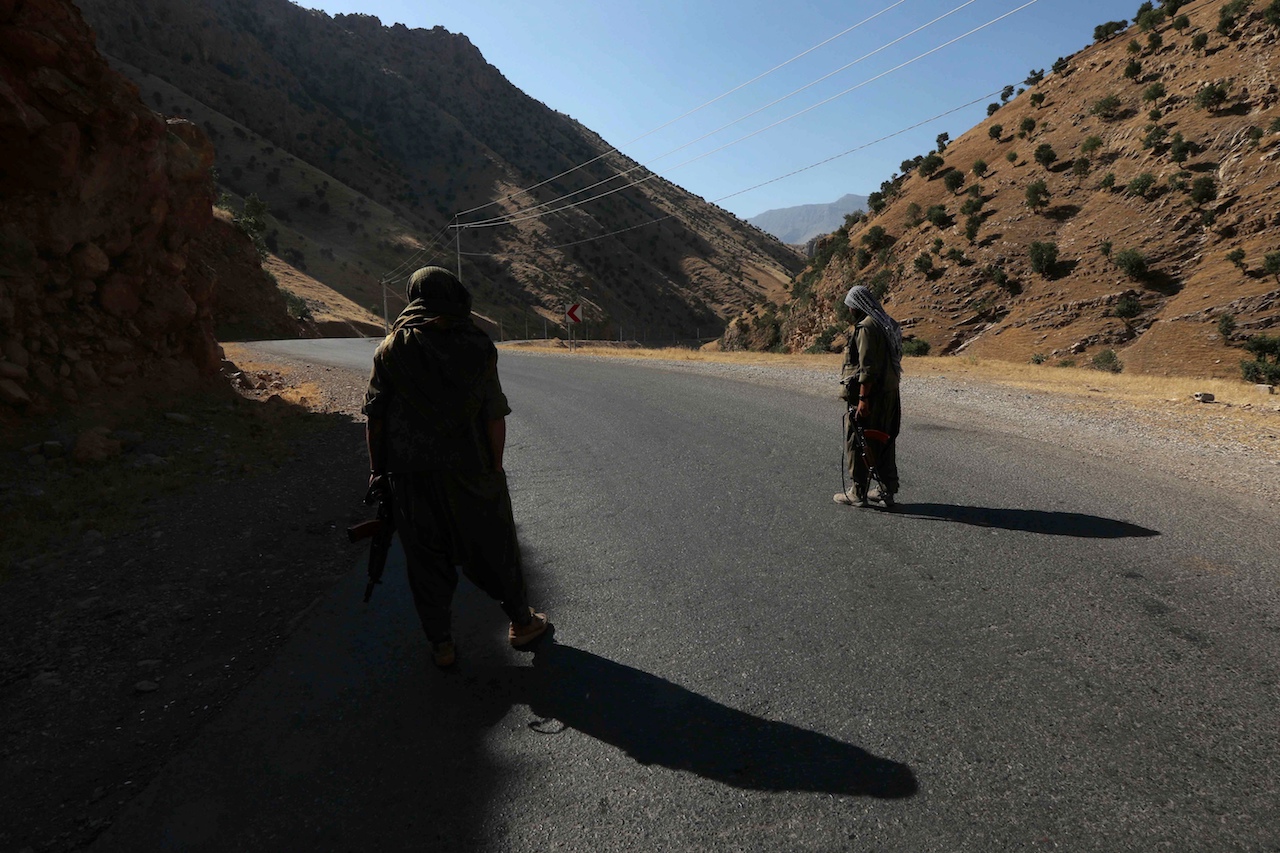 A member of the Kurdistan Workers' Party (PKK) carries an automatic rifle on a road in the Qandil Mountains, the PKK headquarters in northern Iraq (AFP)