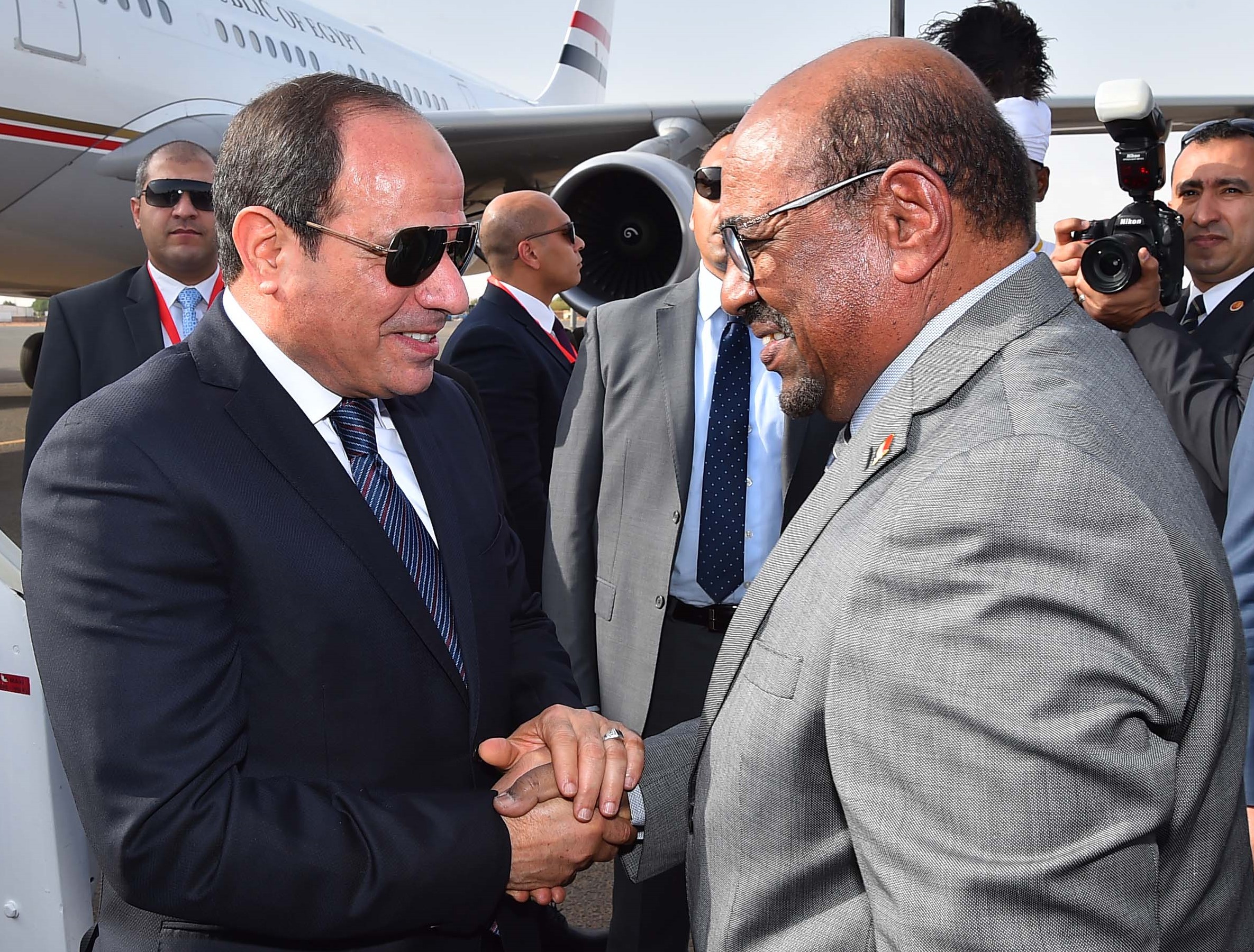 Le président soudanais Omar el-Béchir (à droite) salue son homologue égyptien Abdel Fattah al-Sissi à son arrivée à l’aéroport international de Khartoum, le 19 juillet 2018 (AFP)