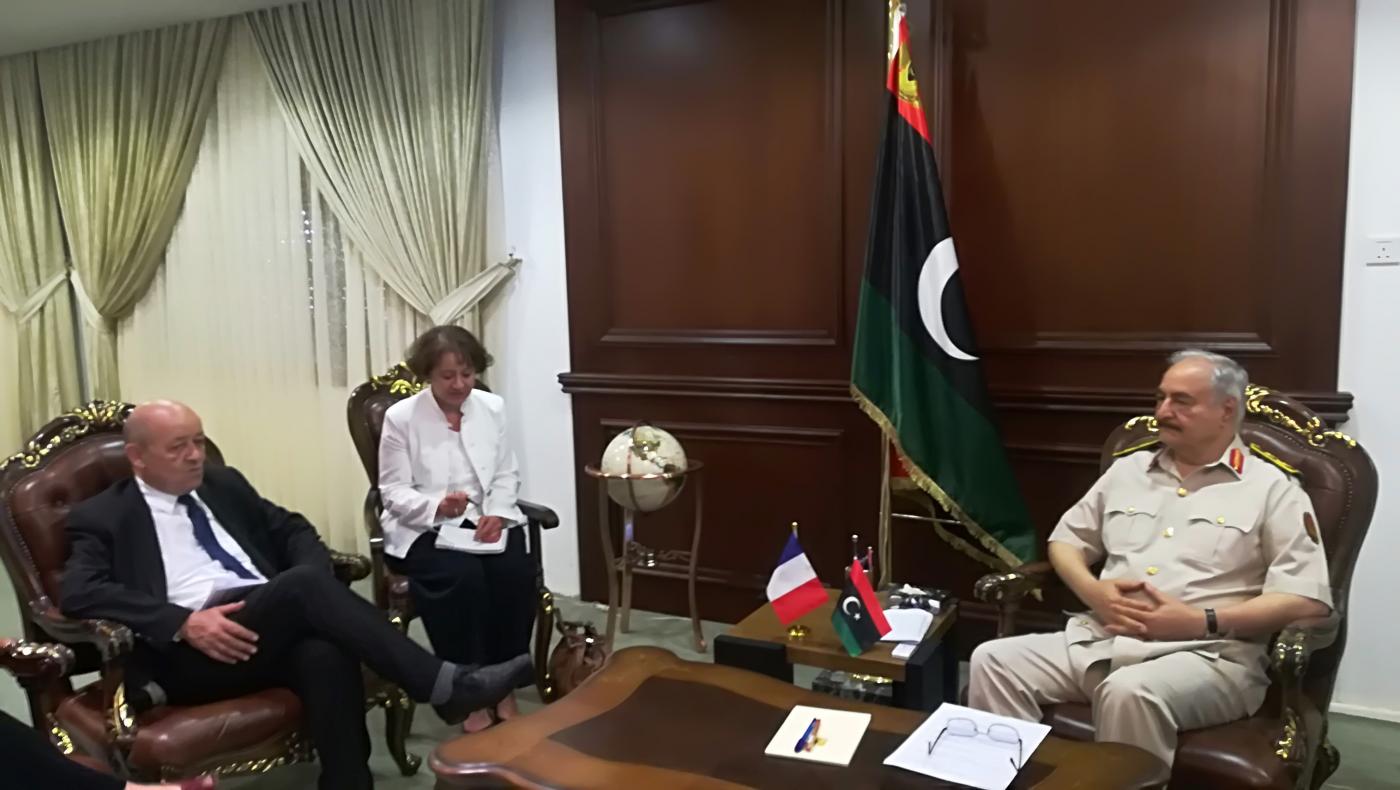 Le ministre français des Affaires étrangères, Jean-Yves Le Drian (à gauche), rencontre le général Khalifa Haftar (à droite) dans la base militaire de Rajma, à 25 kilomètres à l’est de Benghazi, en juillet 2018 (AFP)