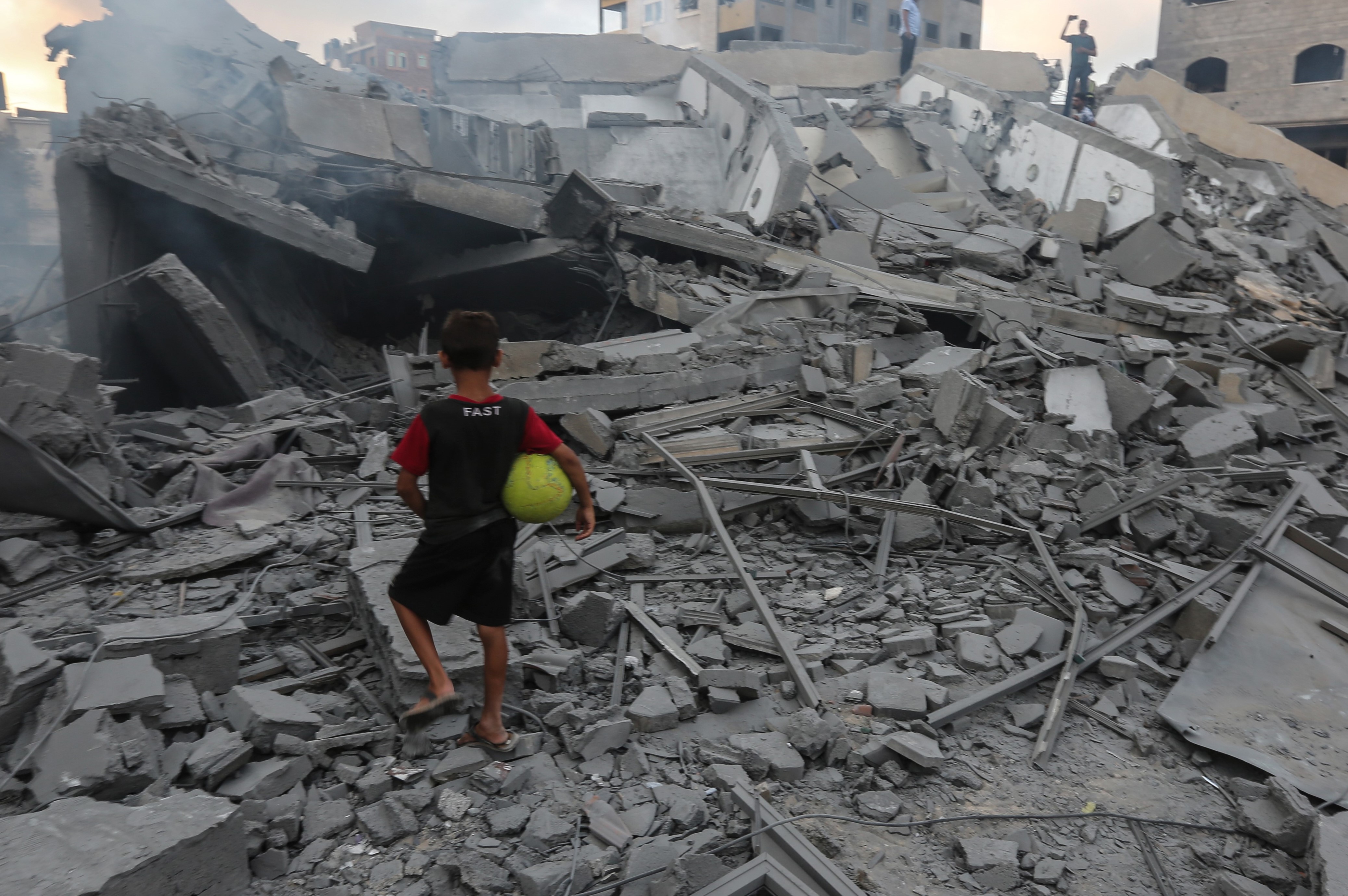 A boy looking at the rubble of the Said al-Mishal Cultural Centre following an Israeli air strike on Gaza City on 9 August 9, 2018 (AFP)