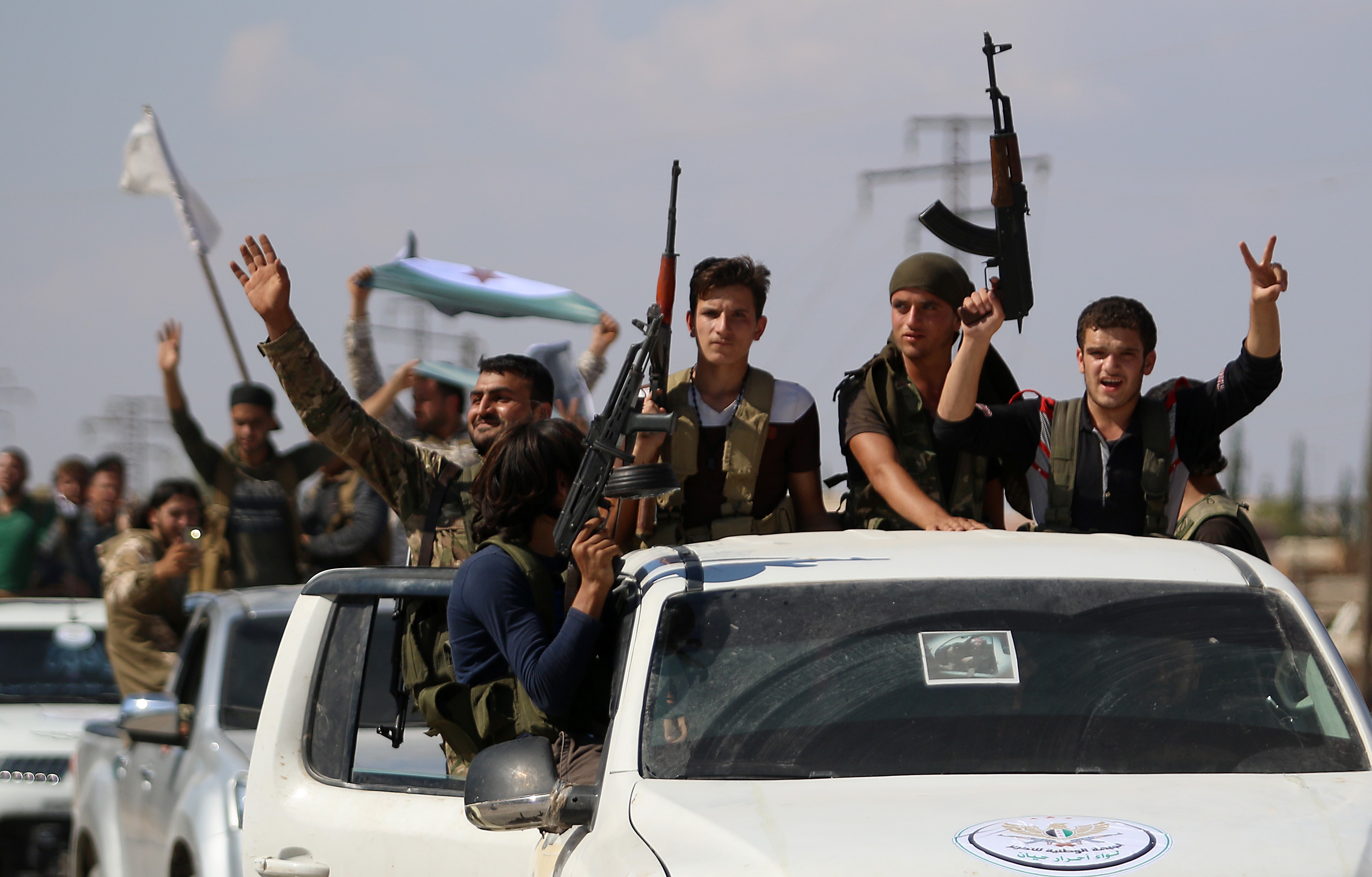  Syrian rebel fighters from the recently-formed "National Liberation Front" parade following military training in Idlib province on 11 September, 2018 (AFP)