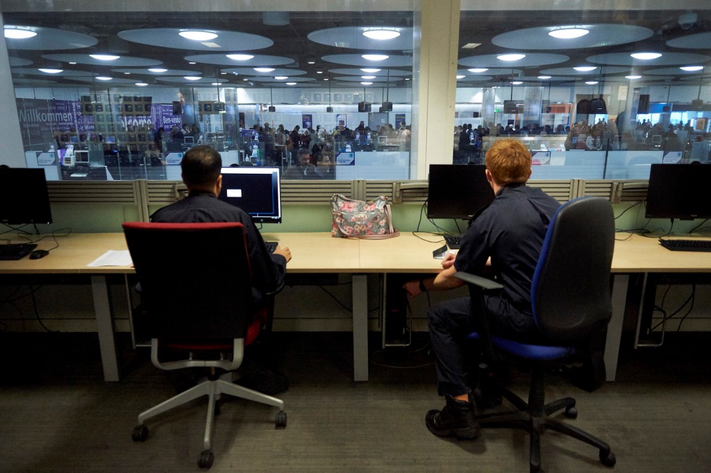 UK Border Force officers work in the watch room overlooking immigration control at Terminal 5 of London Heathrow Airport in west London on 19 December 2018 (AFP)
