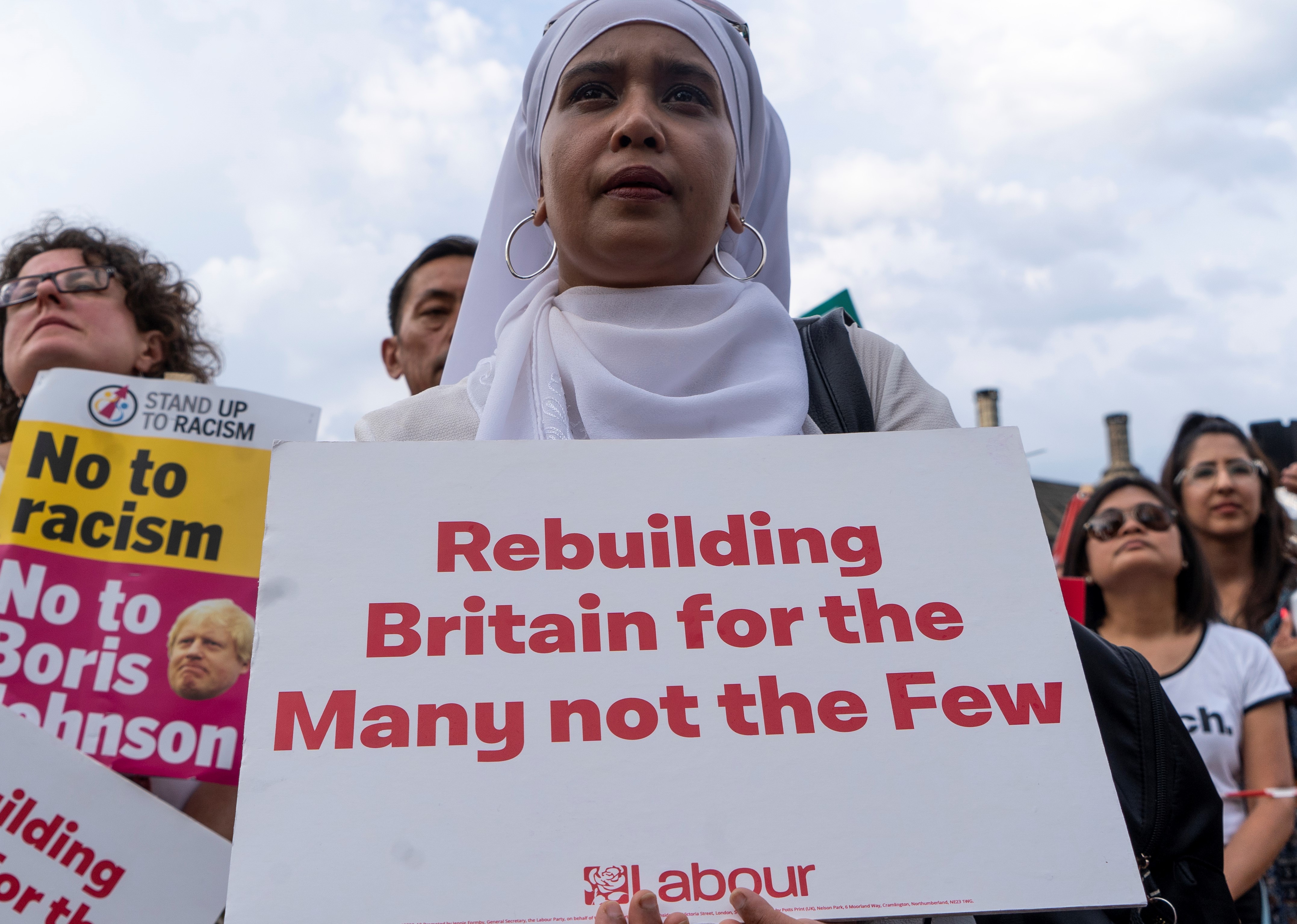 Supporters hold placards as Britain's opposition Labour party leader Jeremy Corbyn addresses a rally calling for a General Election now, in Parliament Square, central London on July 25, 2019.