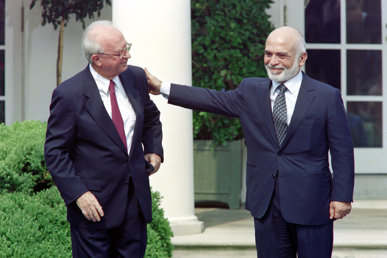 King Hussein of Jordan (R) pats on the shoulder Israeli Prime Minister Yitzhak Rabin at the White House Rose Garden in Washington on 25 July 1994 (AFP)