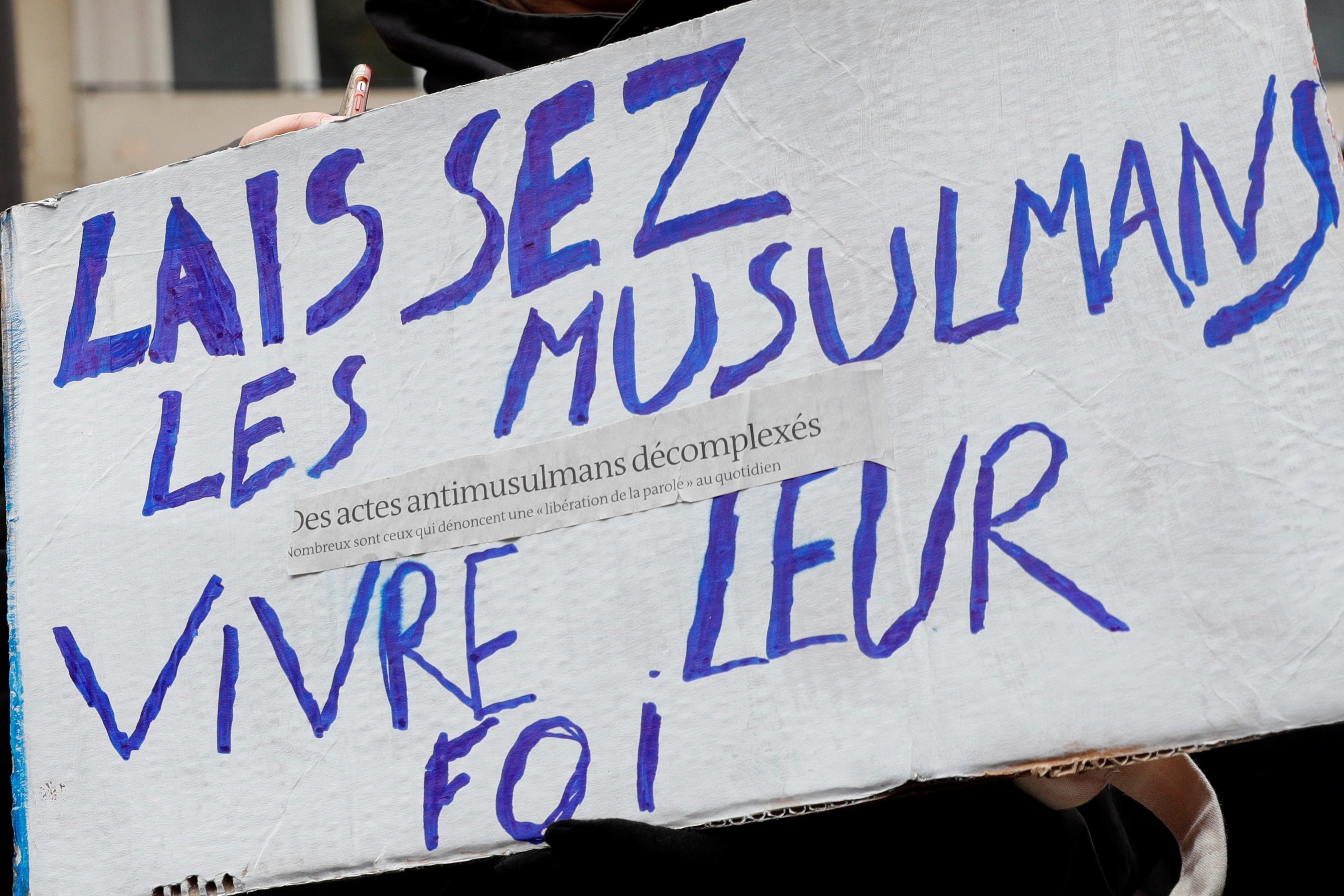 A placard held by a protester reading "Let Muslims live their faith" during march in front of the Gare du Nord, in Paris to protest against Islamophobia, on November 10, 2019.