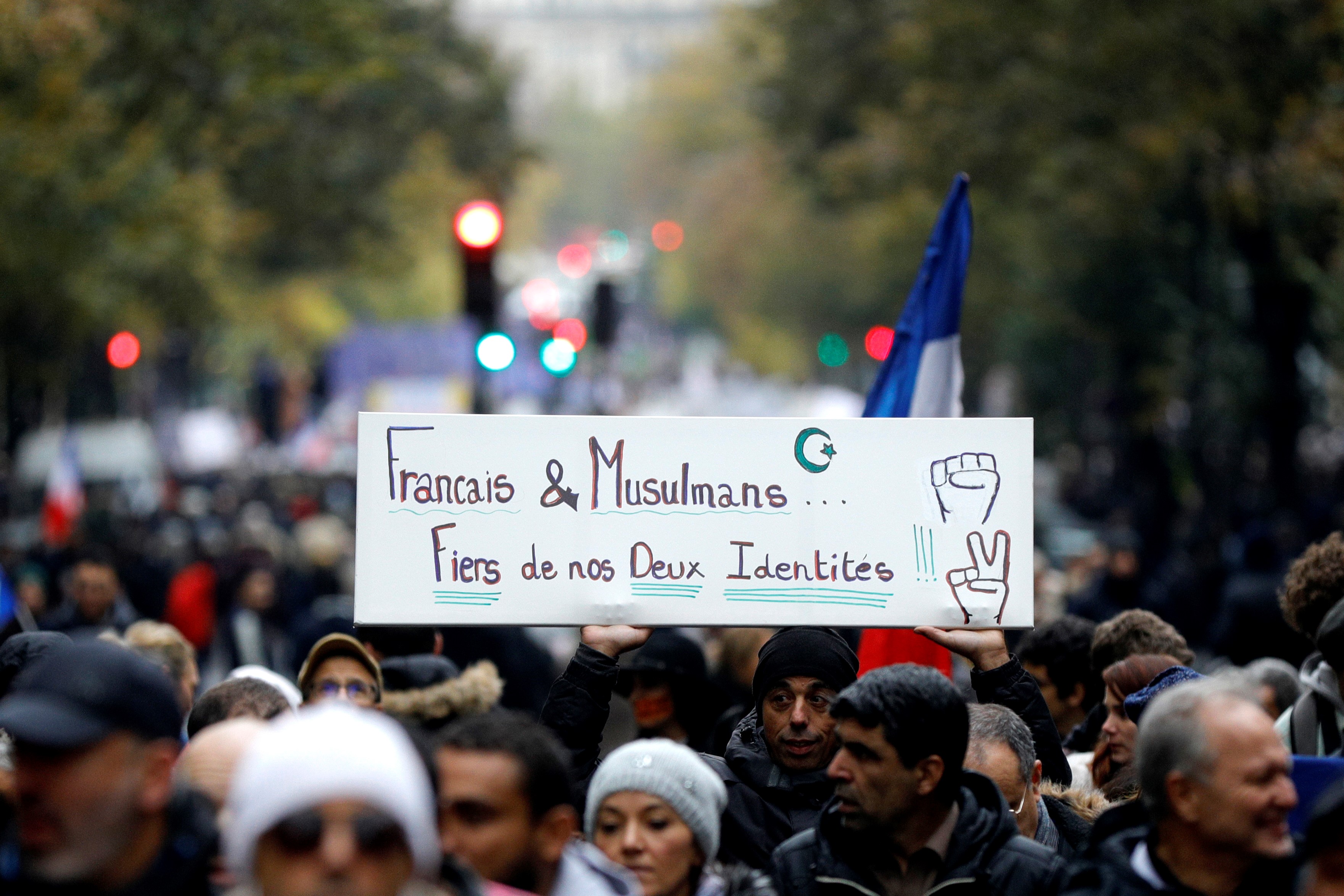Protesters hold a placard reading "French and muslims, proud of our identities" as they march in Paris to protest against Islamophobia, on November 10, 2019.