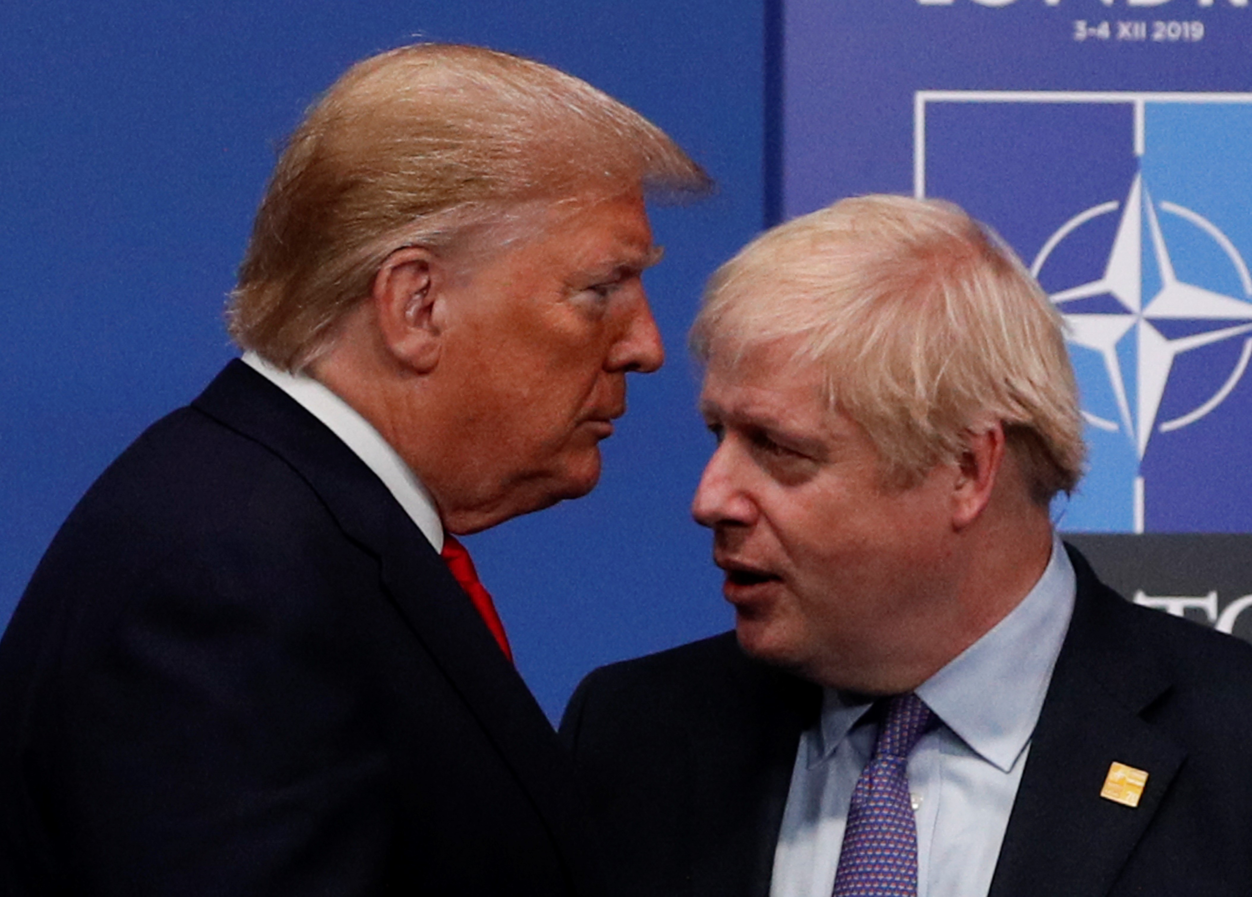 Britain's Prime Minister Boris Johnson (R) greets US President Donald Trump upon arrival for the NATO summit at the Grove hotel in Watford, northeast of London on December 4, 2019.