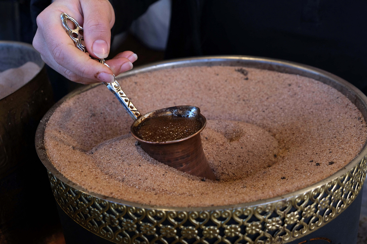 Turkish coffee prepared on heated sand (AFP/ Safin Hamed)
