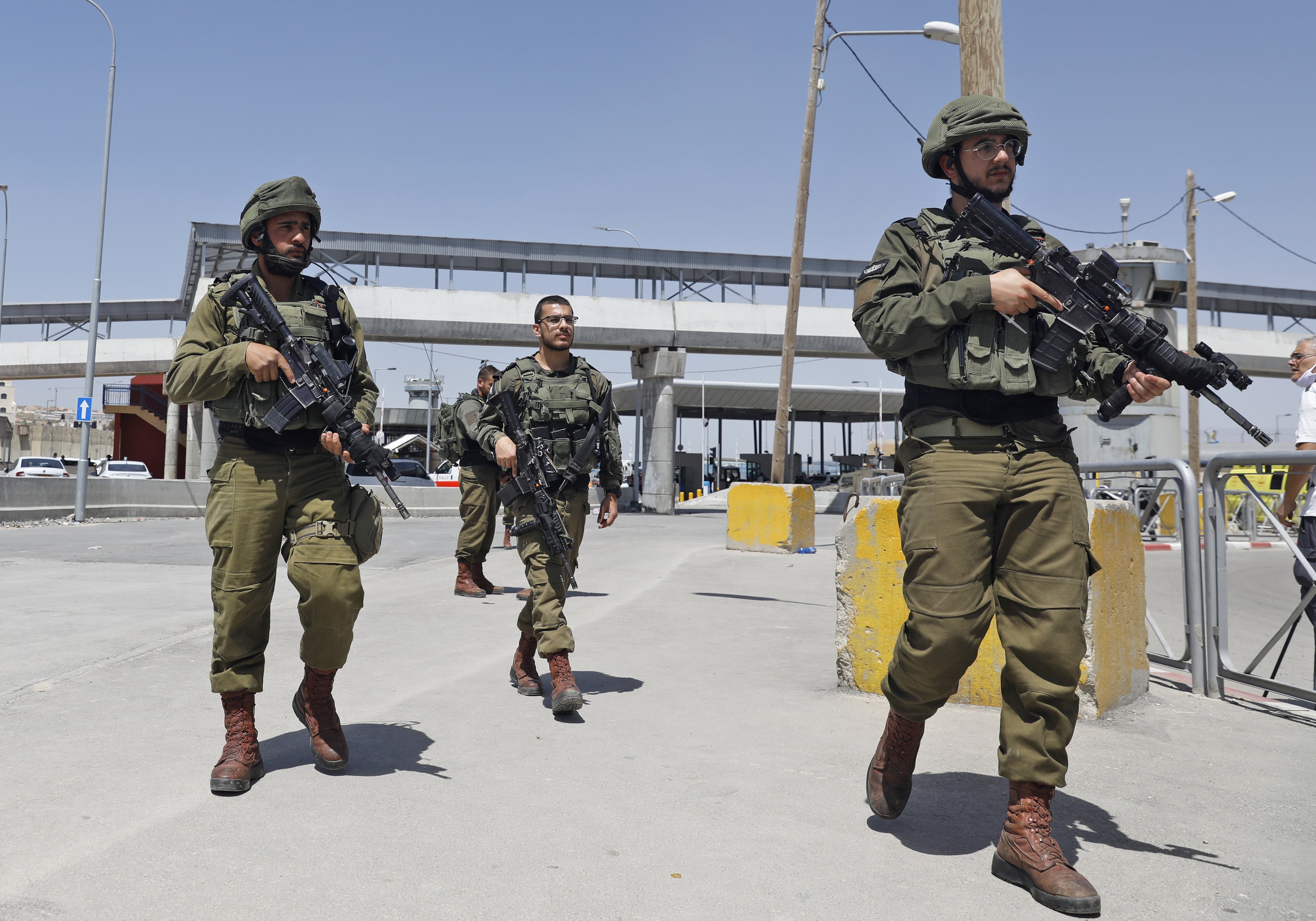 Israeli soldiers gather at a checkpoint in the occupied West Bank in May 2020 (AFP)