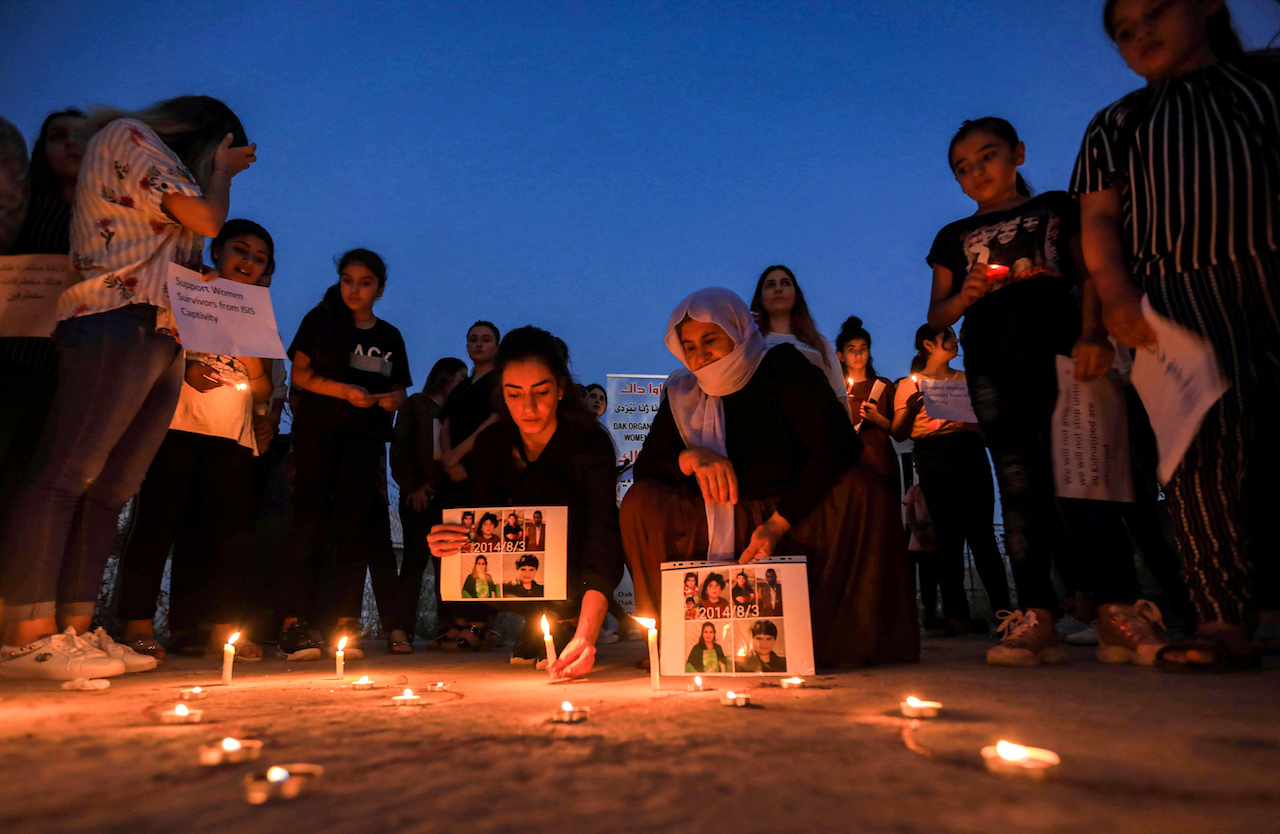 Iraqi Yazidis attend a candle-lit vigil in Iraqi Kurdistan marking sixth anniversary of the Islamic State genocide (AFP)