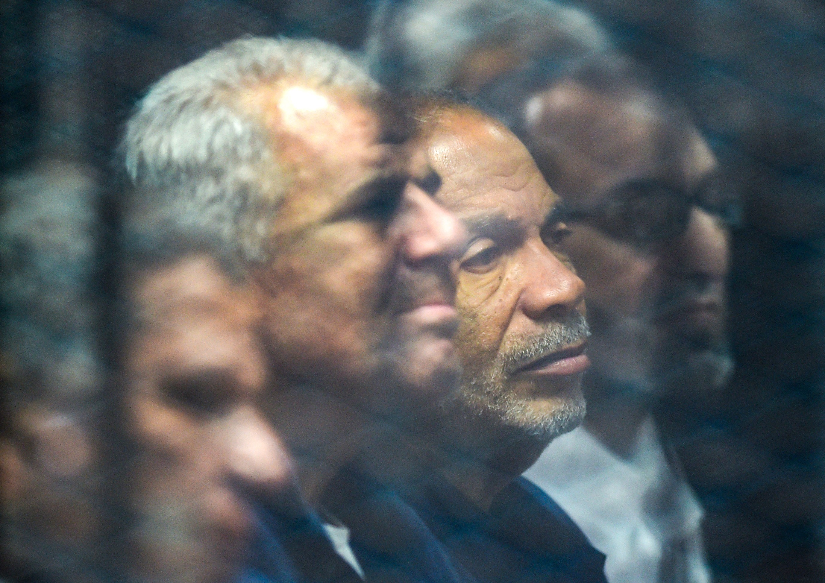 Senior Muslim Brotherhood members behind bars at a make-shift courthouse in southern Cairo on 2 December, 2018 (AFP)