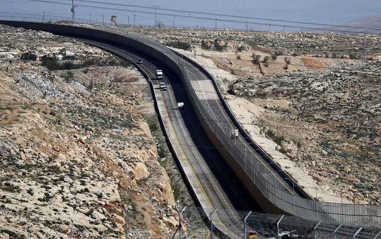 ‘Apartheid Road’ has a wall along its length, dividing Palestinian and Israeli drivers (AFP)