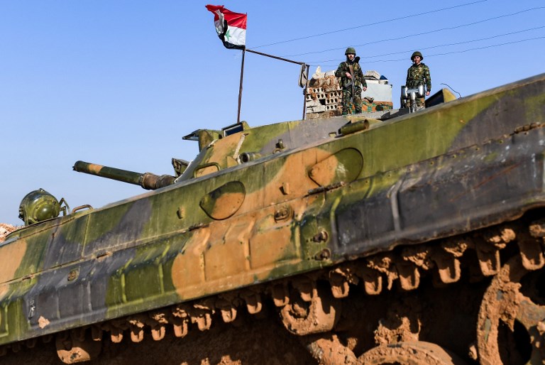 Syrian soldiers in the village of Hawshariya, northeast of Manbij, on 12 January (AFP)