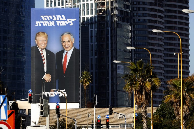 An election billboard shows Israeli Prime Minister Benjamin Netanyahu shaking hands with US President Donald Trump in Tel Aviv on 3 February (AFP)