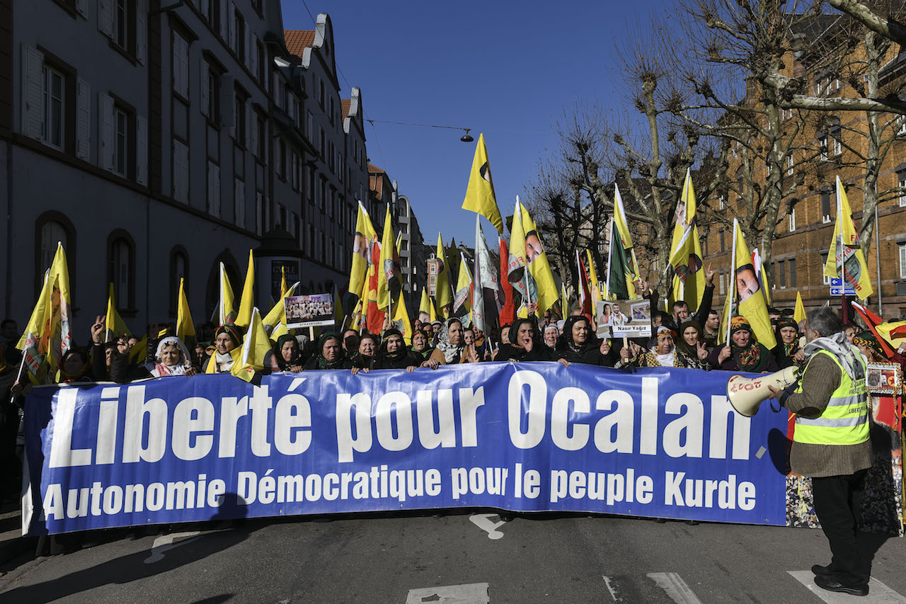Des gens défilent avec une banderole sur laquelle on peut lire « Liberté pour Öcalan » lors d’un rassemblement de soutien au dirigeant kurde emprisonné Abdullah Öcalan (AFP)