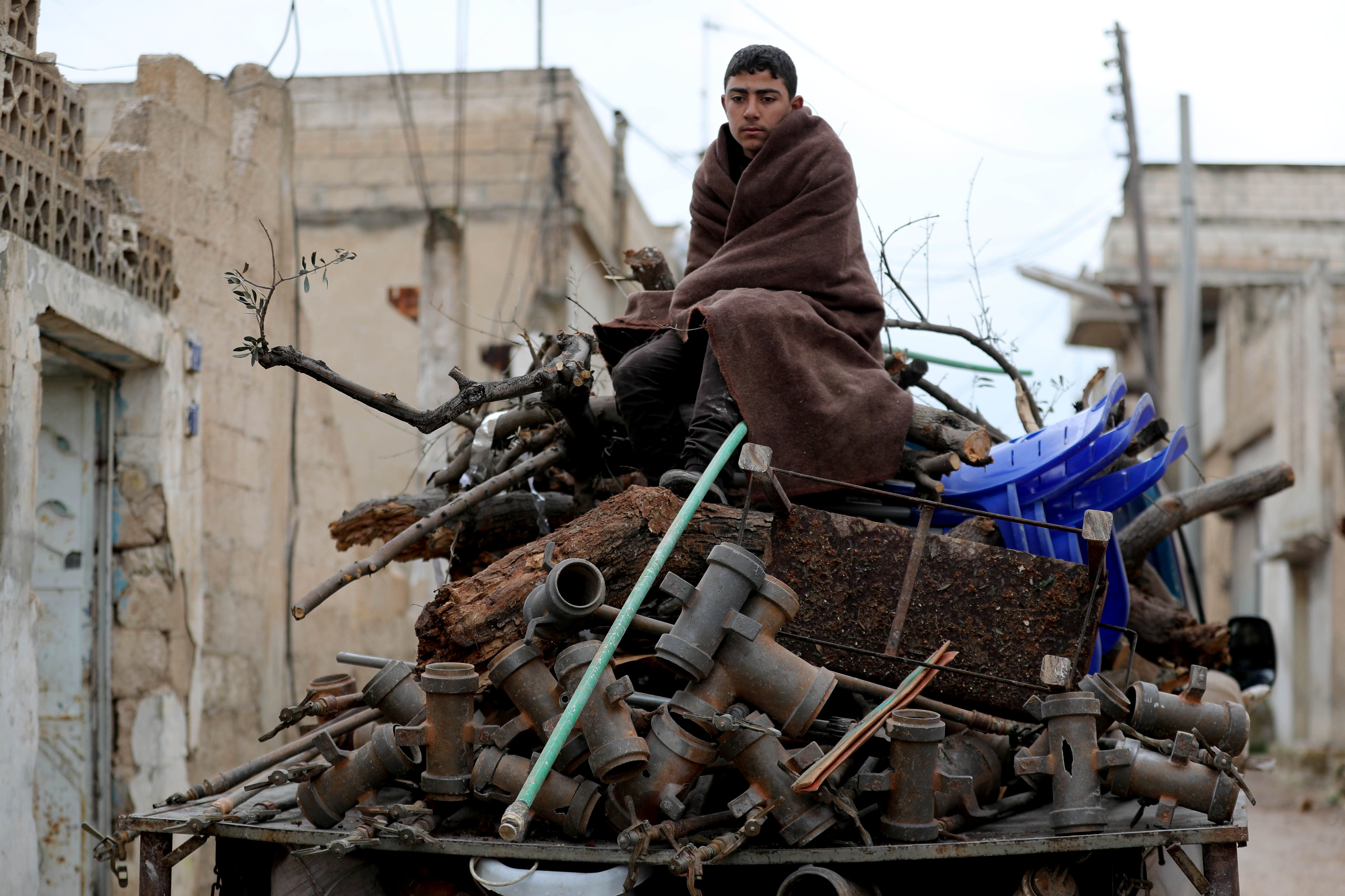 A Syrian youth prepares to flee Khan Sheikhun on 28 February (AFP)