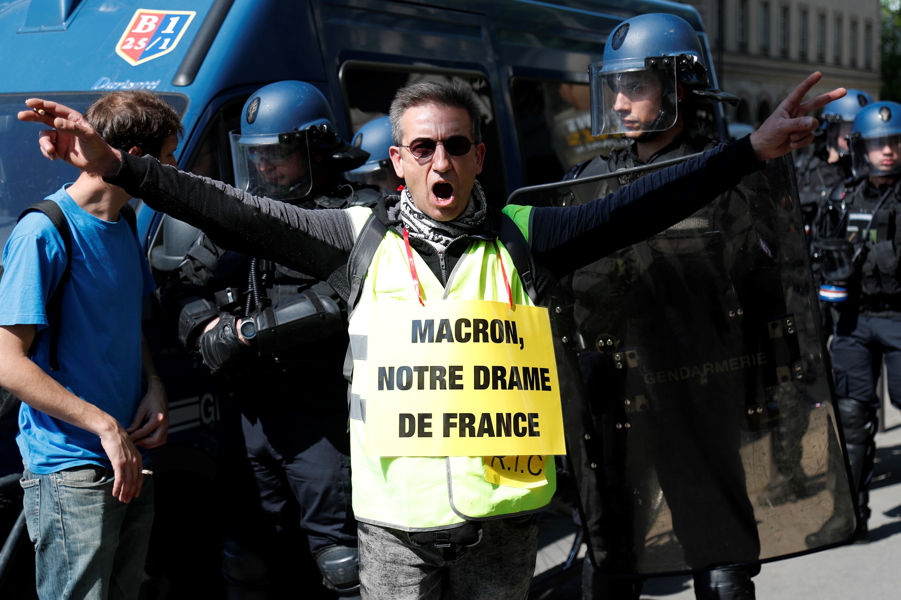   A protester wearing a 'Yellow Vest' (gilet jaune) and sporting a sign reading (a play on word) "Macron, our French drama" in reference to the fire that destroyed the Notre-Dame de Paris Cathedral on 20 April (AFP)