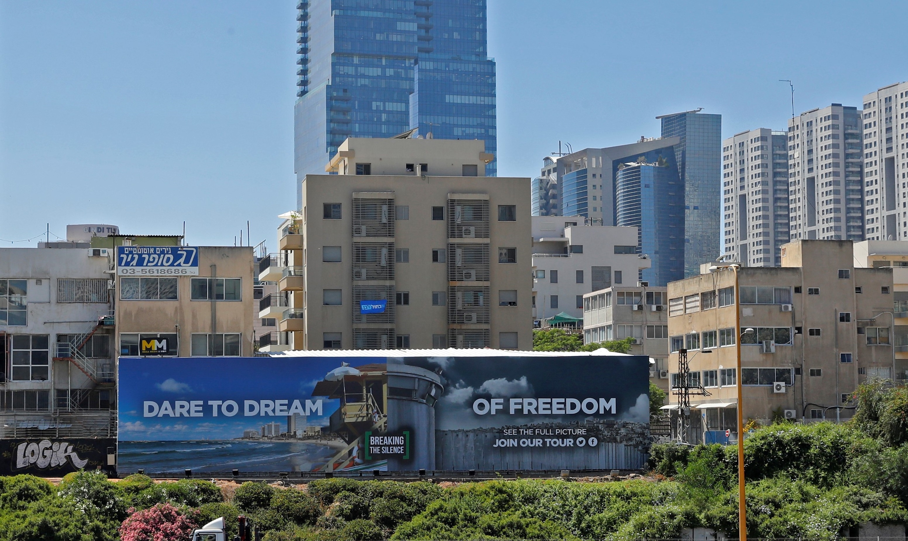 Une photo prise le 13 mai montre une affiche contre l’occupation israélienne de l’ONG Breaking The Silence, érigée dans une rue de Tel Aviv (AFP)