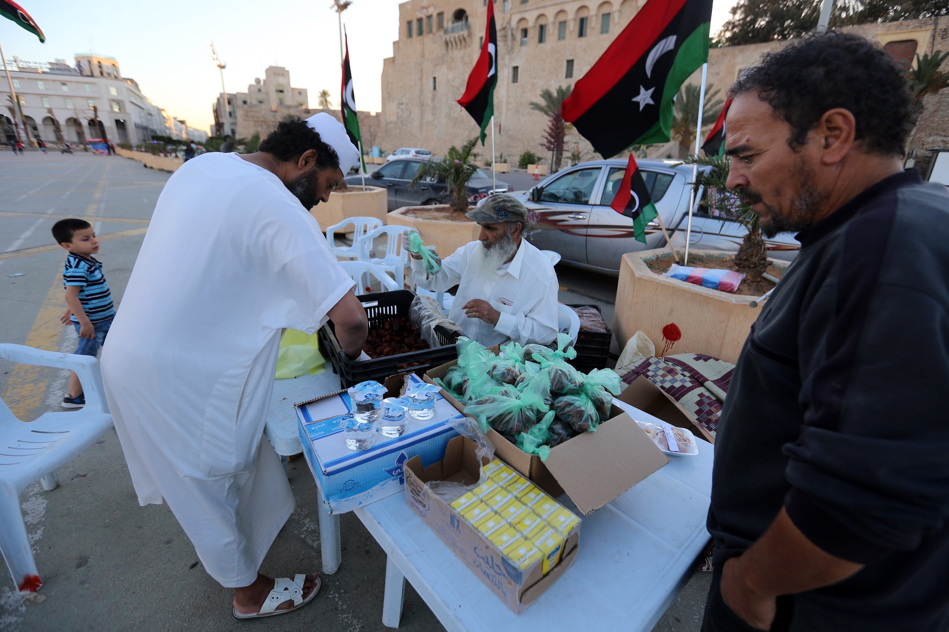  Libyans prepare to distribute snacks and water to people to break their fast during Ramadan in the Martyrs Square of the capital Tripoli, on 15 May (AFP)
