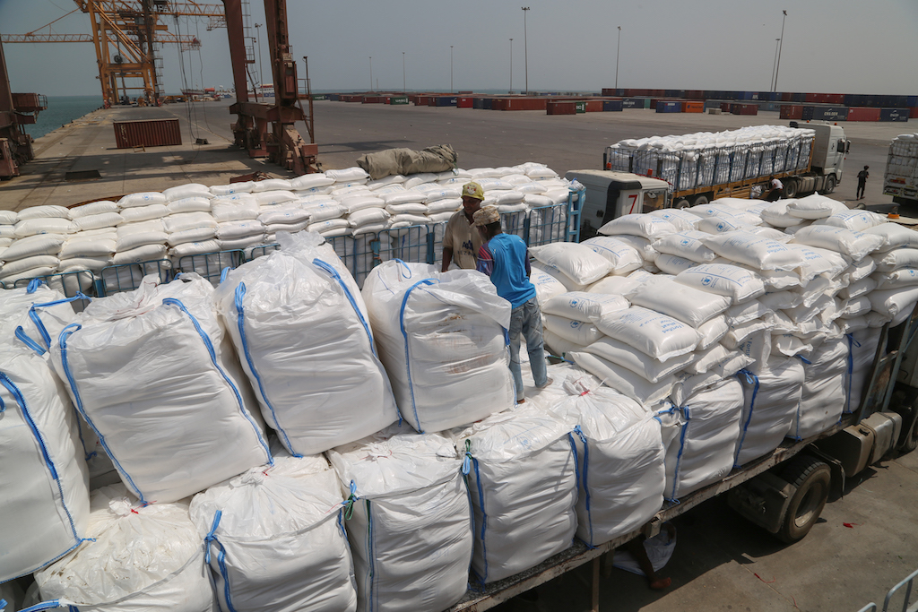 Yemenis receive sacks of food aid packages from the World Food Programme (WFP) in the Yemeni port city of Hodeidah (AFP)