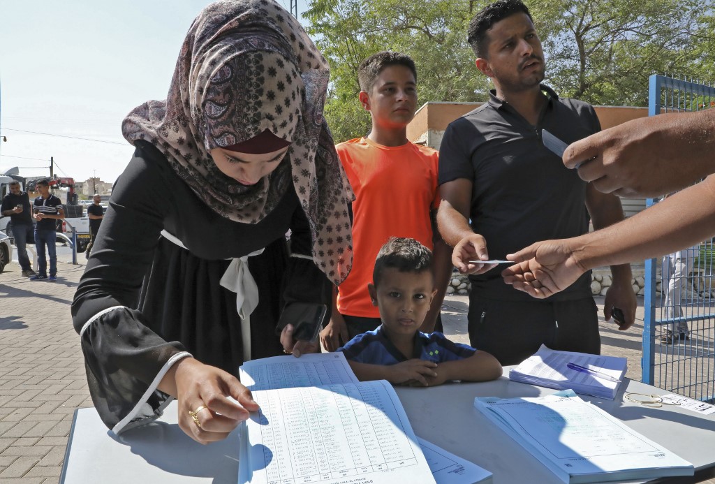 Bedouins from the Negev search for their names outside a polling station in Shaqib al-Salam near the southern Israeli city of Beersheva during Israel's parliamentary election (AFP)