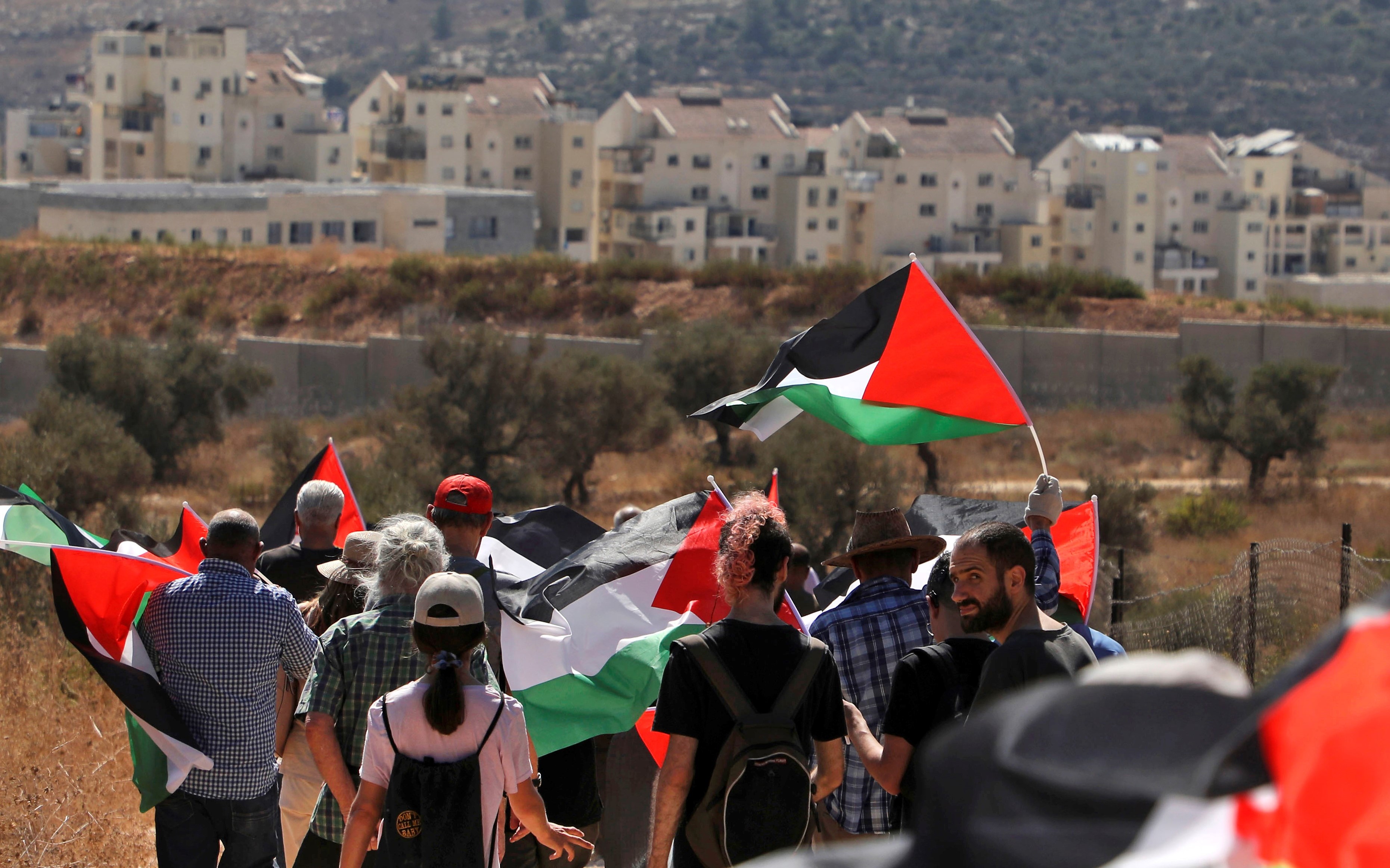  Palestinian and foreign demonstrators in Bilin opposite the settlements bloc of Modiin Illit (background) in the occupied West Bank on 4 October