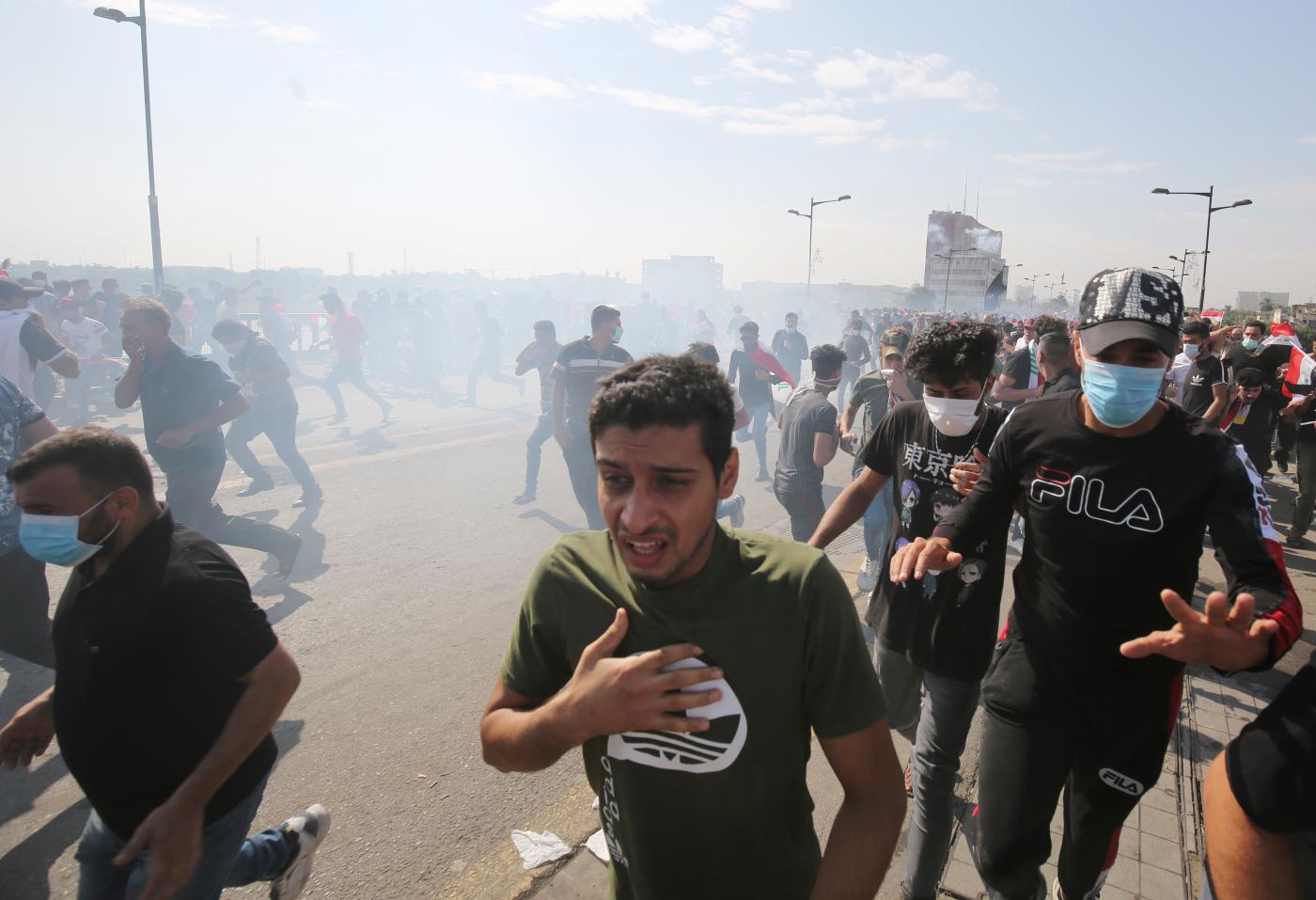 Des manifestants se mettent à l’abri alors que les forces de sécurité utilisent des gaz lacrymogènes lors d’une manifestation antigouvernementale dans le centre de Bagdad le 25 octobre 2019 (AFP)