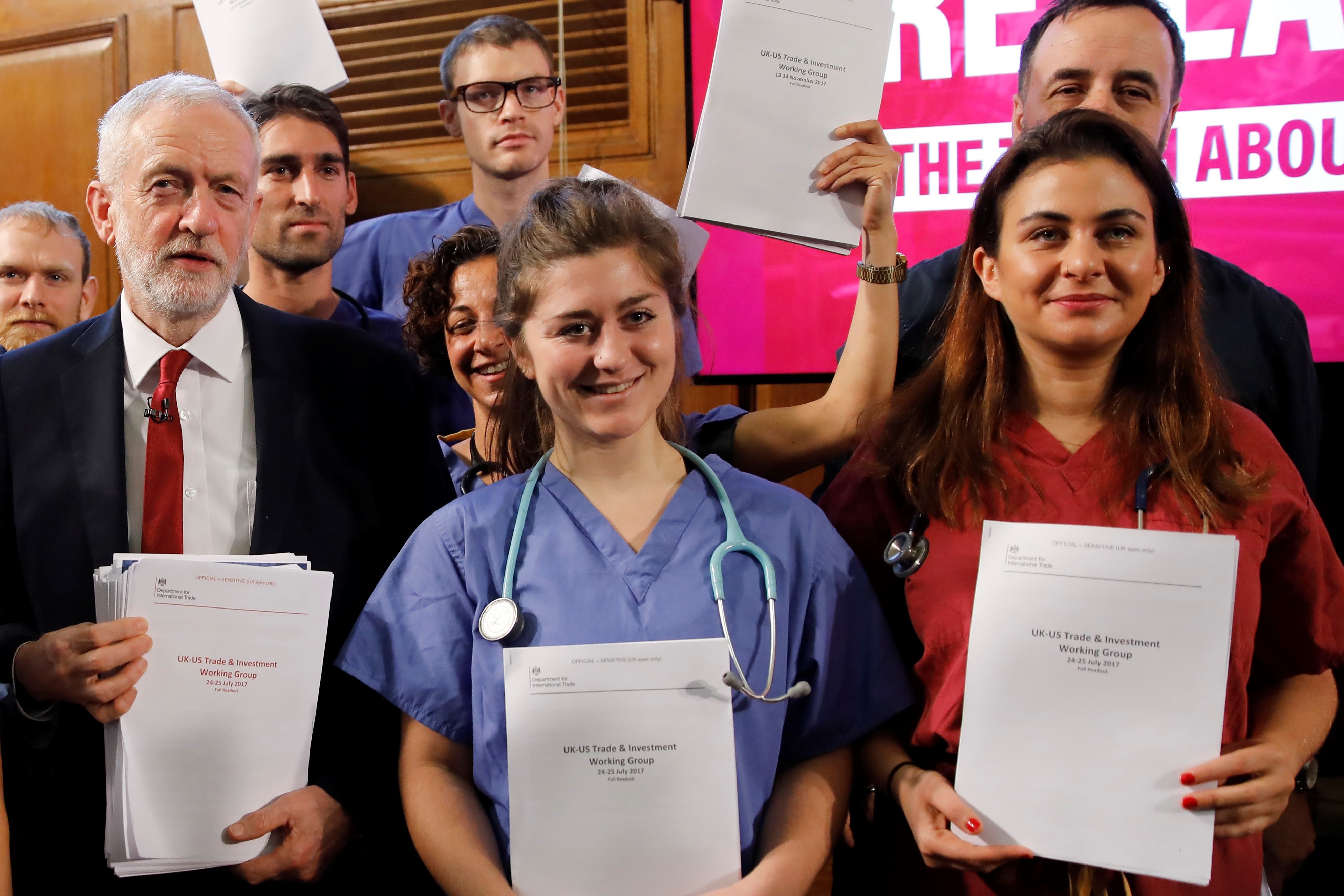 Opposition Labour party leader Jeremy Corbyn (C) poses with NHS workers holding documents regarding the Conservative government's UK-US trade talks in London after a press conference on November 27, 2019.