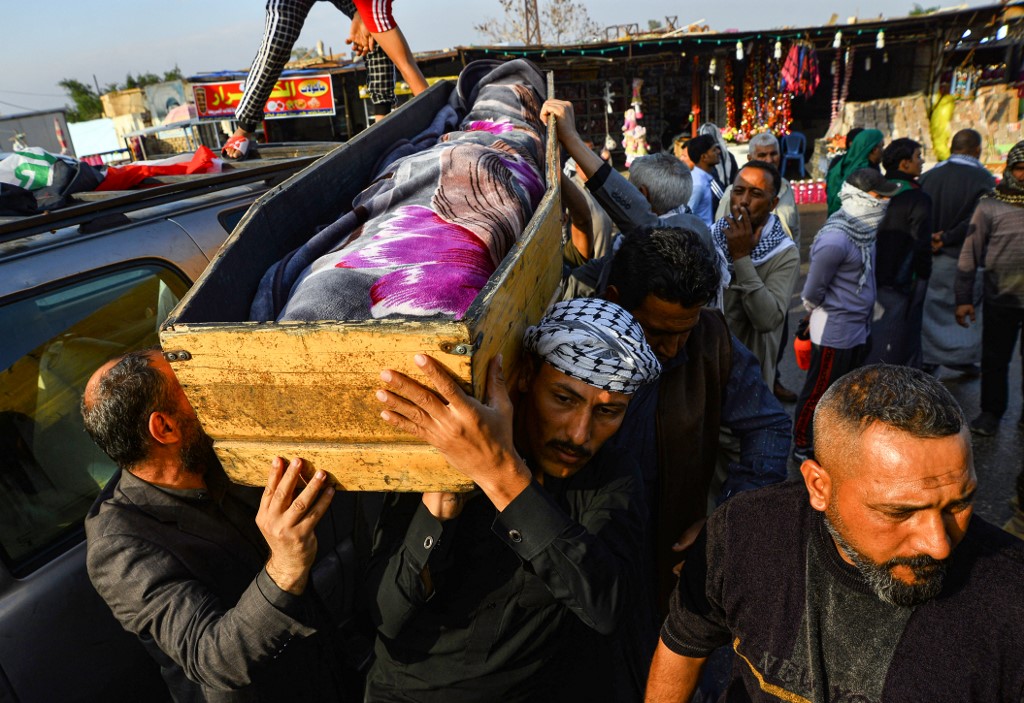 Iraqi mourners carry the coffin of an anti-government protester who was killed in Nasiriyah during clashes between anti-government protesters and security forces in November (AFP)