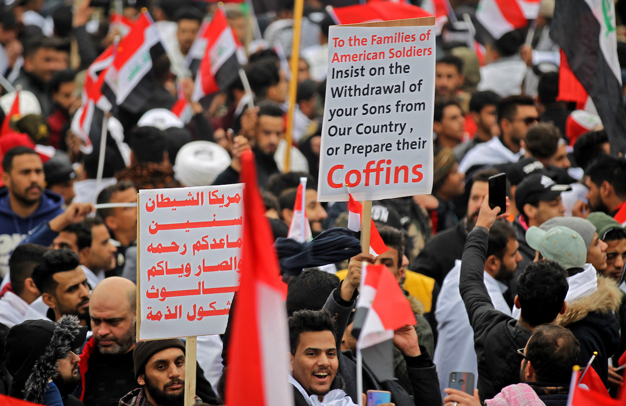 Protesters raise placards as supporters of Iraqi cleric Moqtada Sadr gather in the capital Baghdad for a "million-strong" march to demand an end to the presence of US forces in their country (AFP)