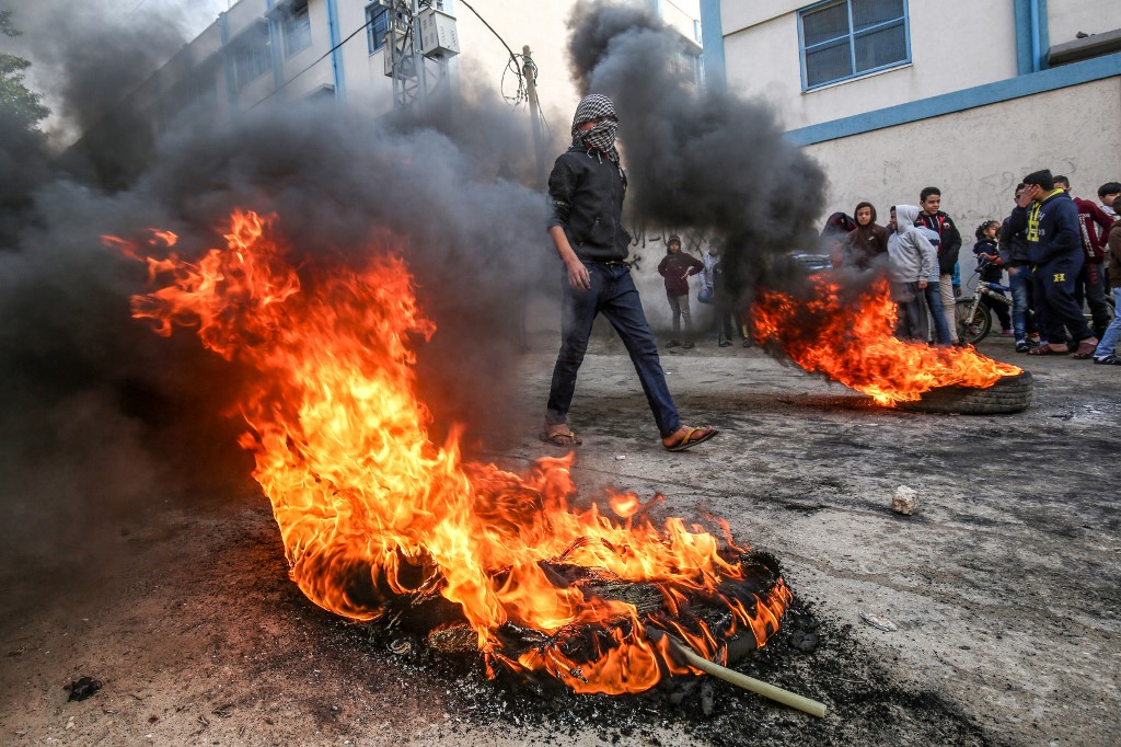 Palestinians in Khan Younis inside the Gaza Strip burn tyres in protest to Trump's deal (AFP)