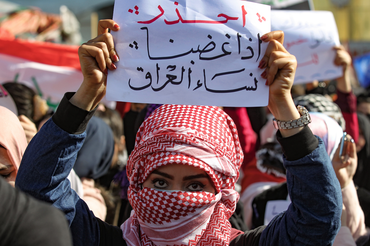 Iraqi women raise placards as they take part in an anti-government demonstration in the capital Baghdad's Tahrir Square. The placard reads in Arabic: "Beware of Iraqi women's anger (AFP)