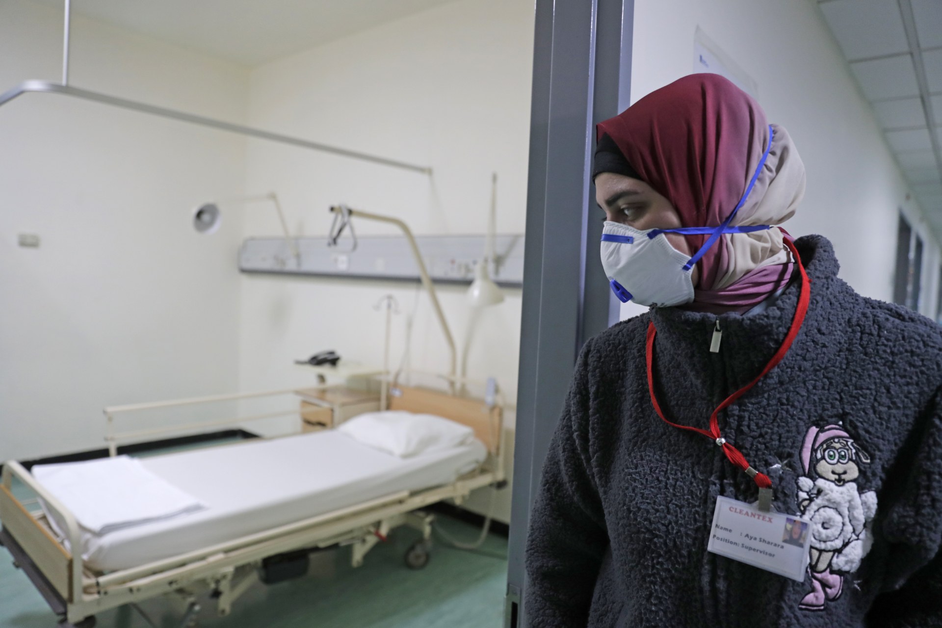 A Lebanese employee wearing a protective mask looks at a bed in a ward where the first case of coronavirus in the country is being treated, at the Rafic Hariri University Hospital (AFP)