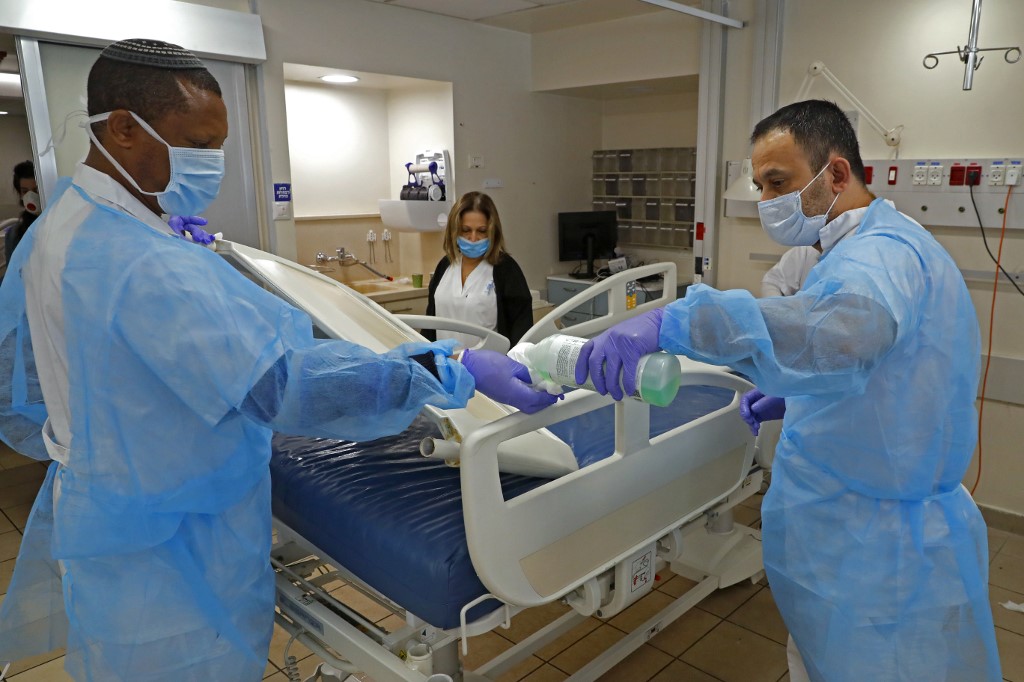 Le personnel du centre médical Sourasky (hôpital Ichilov) à Tel Aviv désinfecte une section dédiée aux malades du COVID-19, le 19 mars 2020 (AFP)