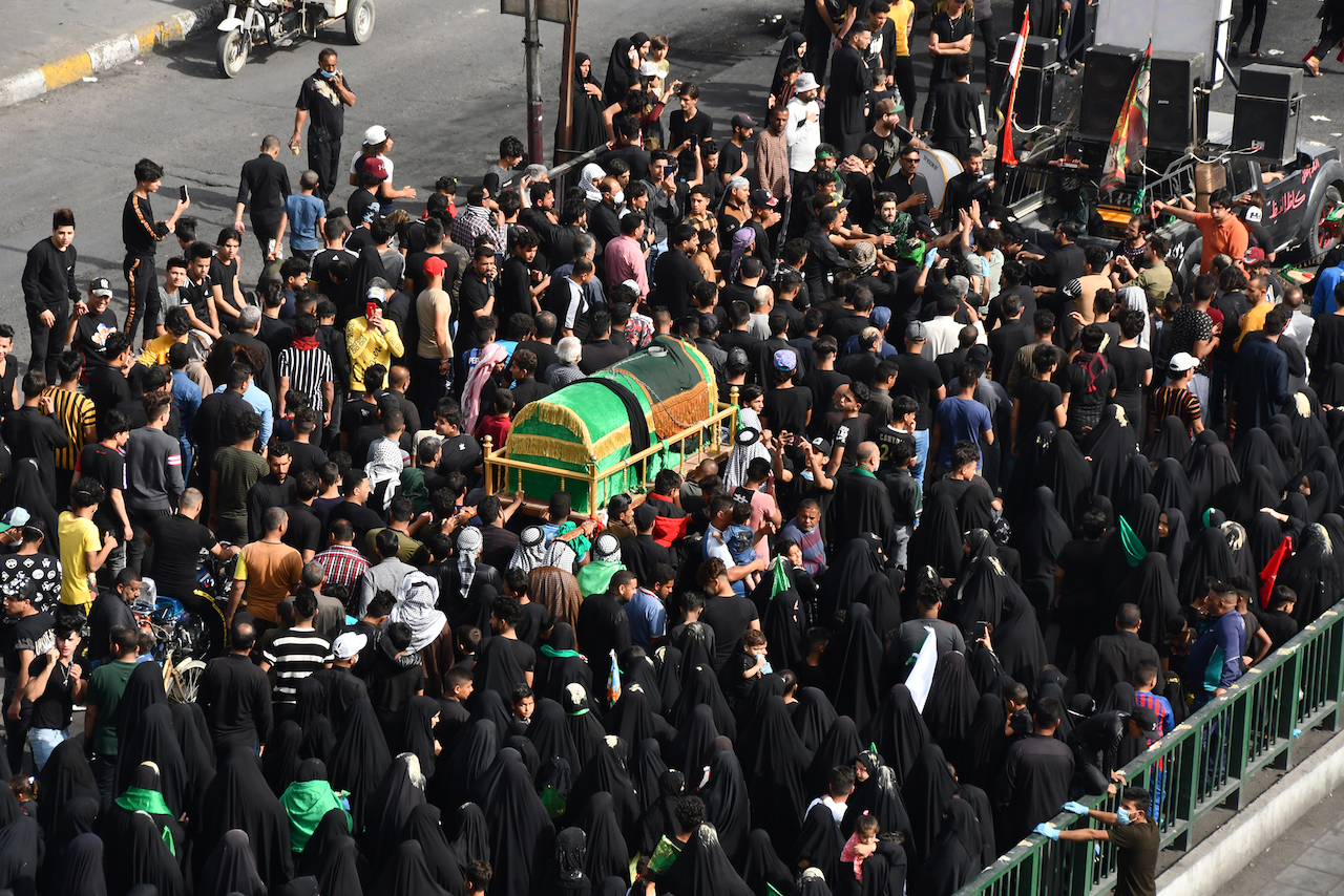 Iraqi Shiite pilgrims carry a mock coffin on their shoulders to mark the anniversary of the death of Imam Moussa al-Kadhim, as they defy a curfew imposed by the authorities to prevent the spread of novel coronavirus COVID-19, in Iraq's southern city of Nasiriyah in Dhi Qar province