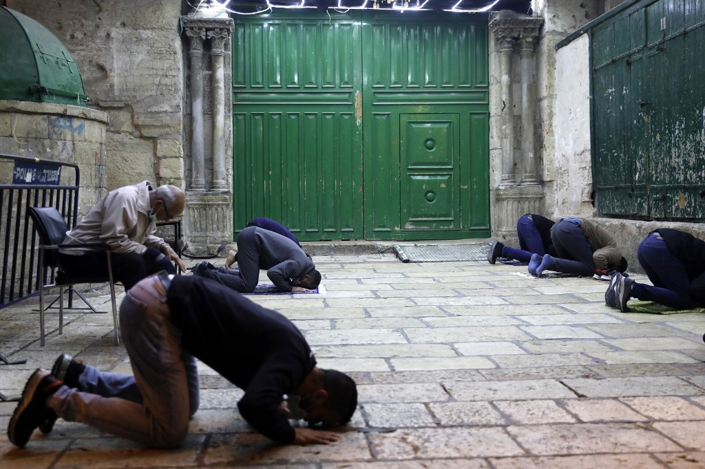Des fidèles palestiniens font la prière du tarawih à l’extérieur de l’esplanade des Mosquées à Jérusalem, fermée en raison du coronavirus, le 27 avril 2020 (AFP)