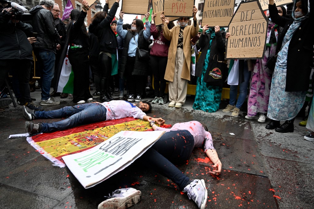 Des manifestants tiennent des pancartes « Reposez en paix les droits de l’homme » lors de la manifestation contre le soutien du gouvernement espagnol au plan d’autonomie du Maroc pour le Sahara occidental, à Madrid, le 26 mars 2022 (AFP/Pierre-Philippe Marcou)