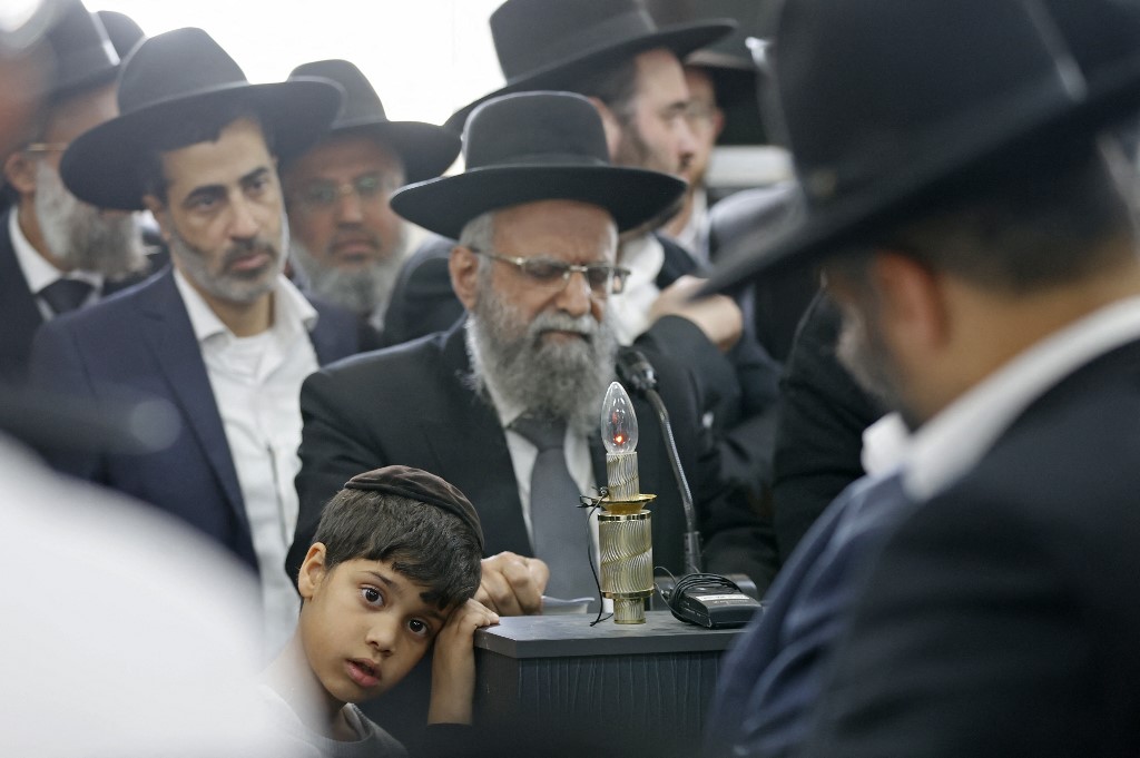 Des personnes participent aux funérailles de Yaakov Shalom, l’une des cinq victimes de la fusillade du 29 mars 2022 (AFP)