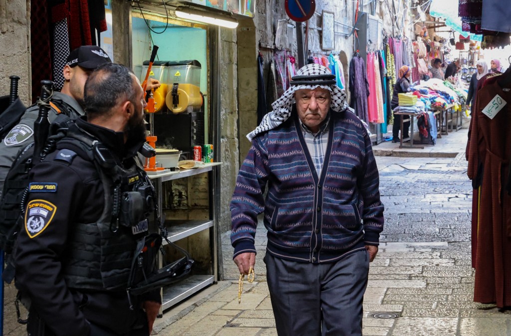 Israeli forces stand guard as an elderly Palestinian walks past in Jerusalem's Old City. (AFP/file)