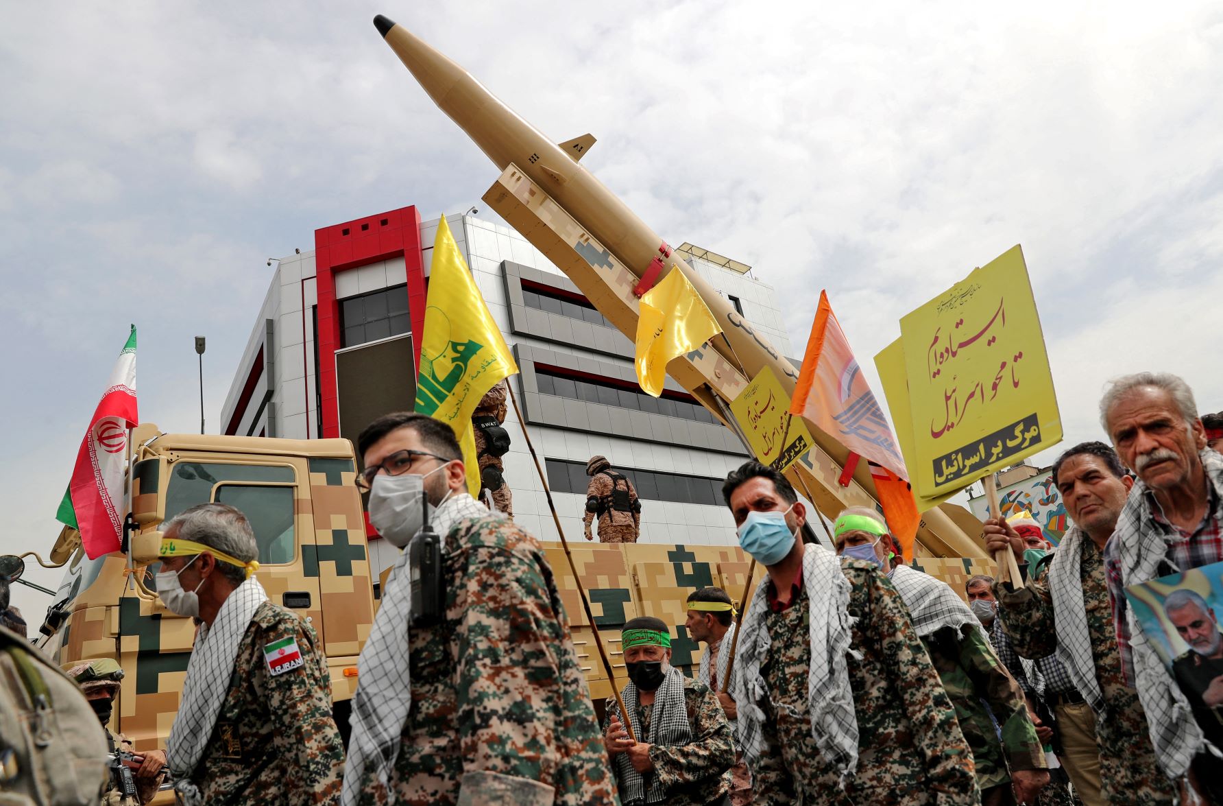 Iranian Basij paramilitary forces take part in a rally marking al-Quds (Jerusalem) day near a Shahab-3 missile in a street in the capital Tehran, on April 29, 2022 (AFP)