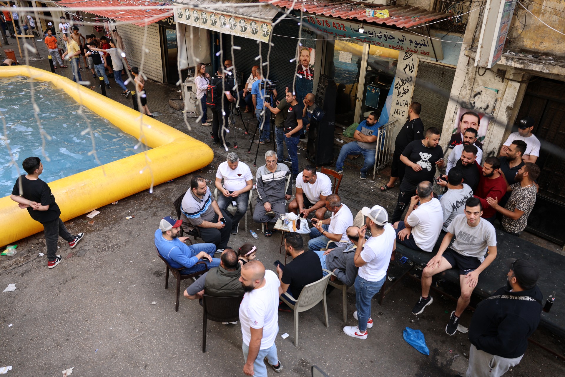 Men sit around an inflatable swimming pool installed by supporters of former Lebanese prime minister Saad Hariri (AFP)