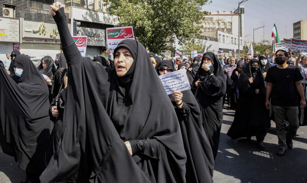 Women and men chant slogans as they march in a pro-hijab rally in Iran's capital Tehran on September 23, 2022. 