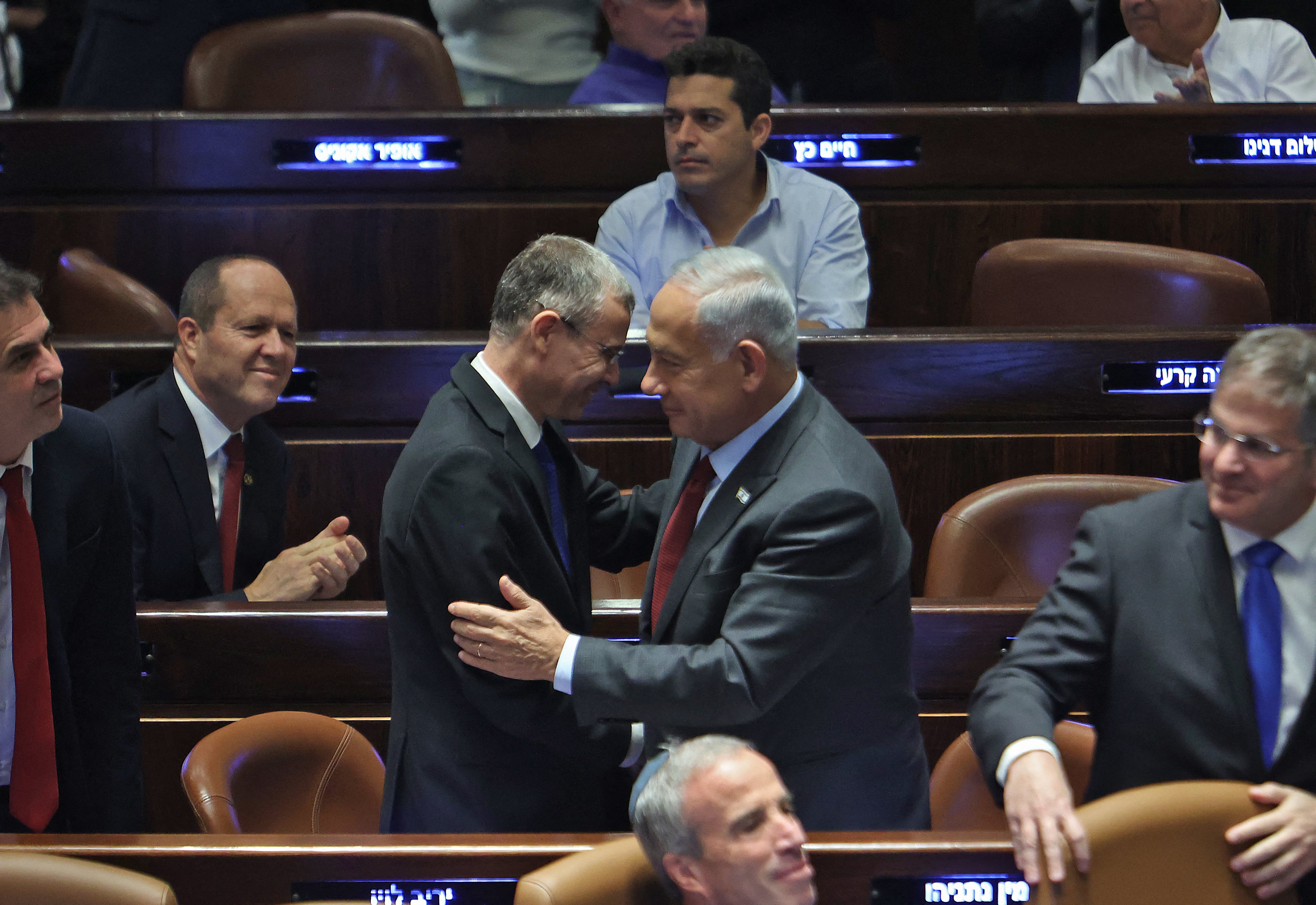 Yariv Levin greets Prime Minister Benjamin Netanyahu in the Knesset in Jerusalem on 13 December 2022 (AFP)
