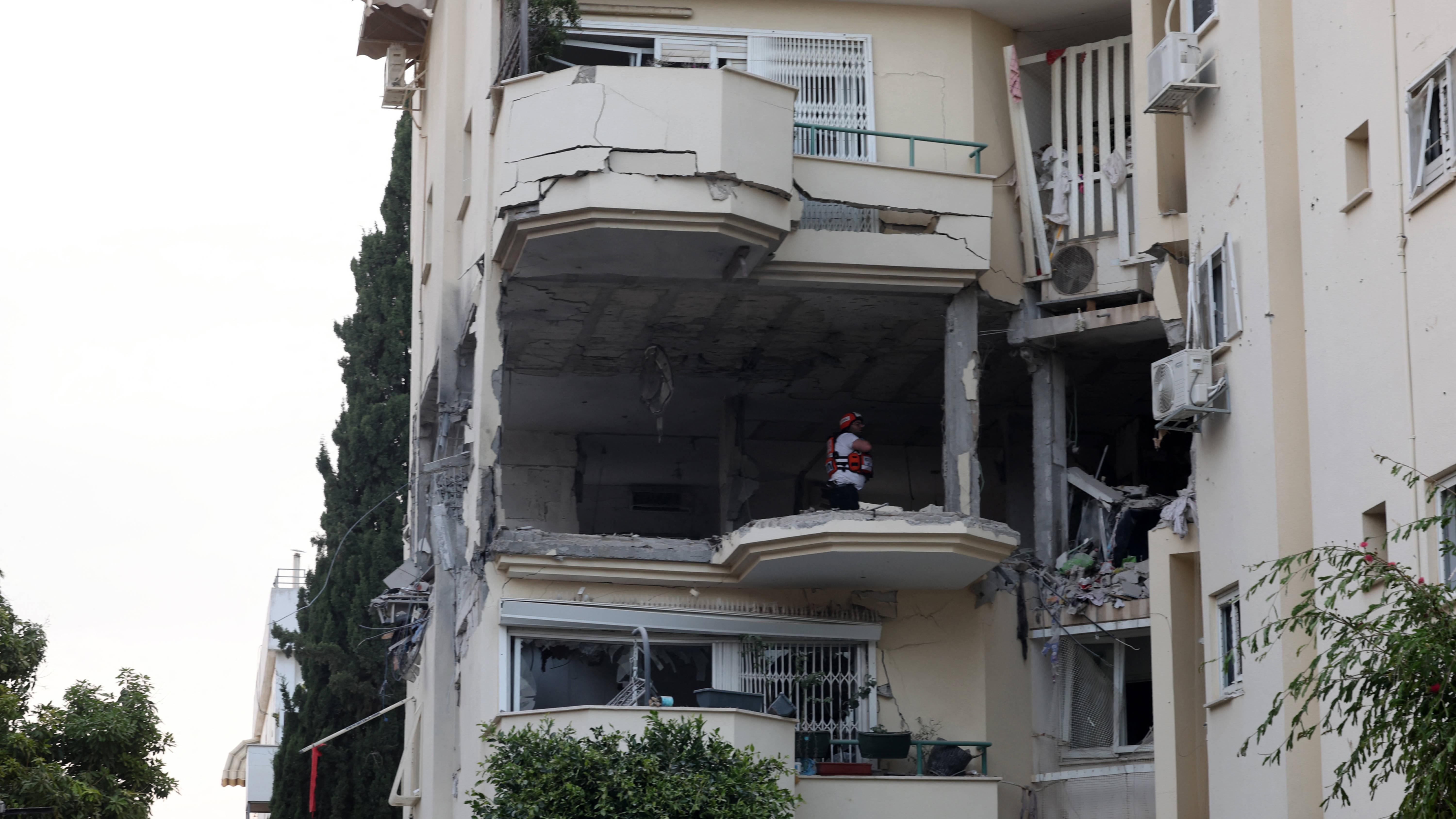 A rescuers checks the damage in a building hit by a rocket fired from the Gaza strip, in Rehovot near Tel Aviv, on 11 May 2023 (AFP)