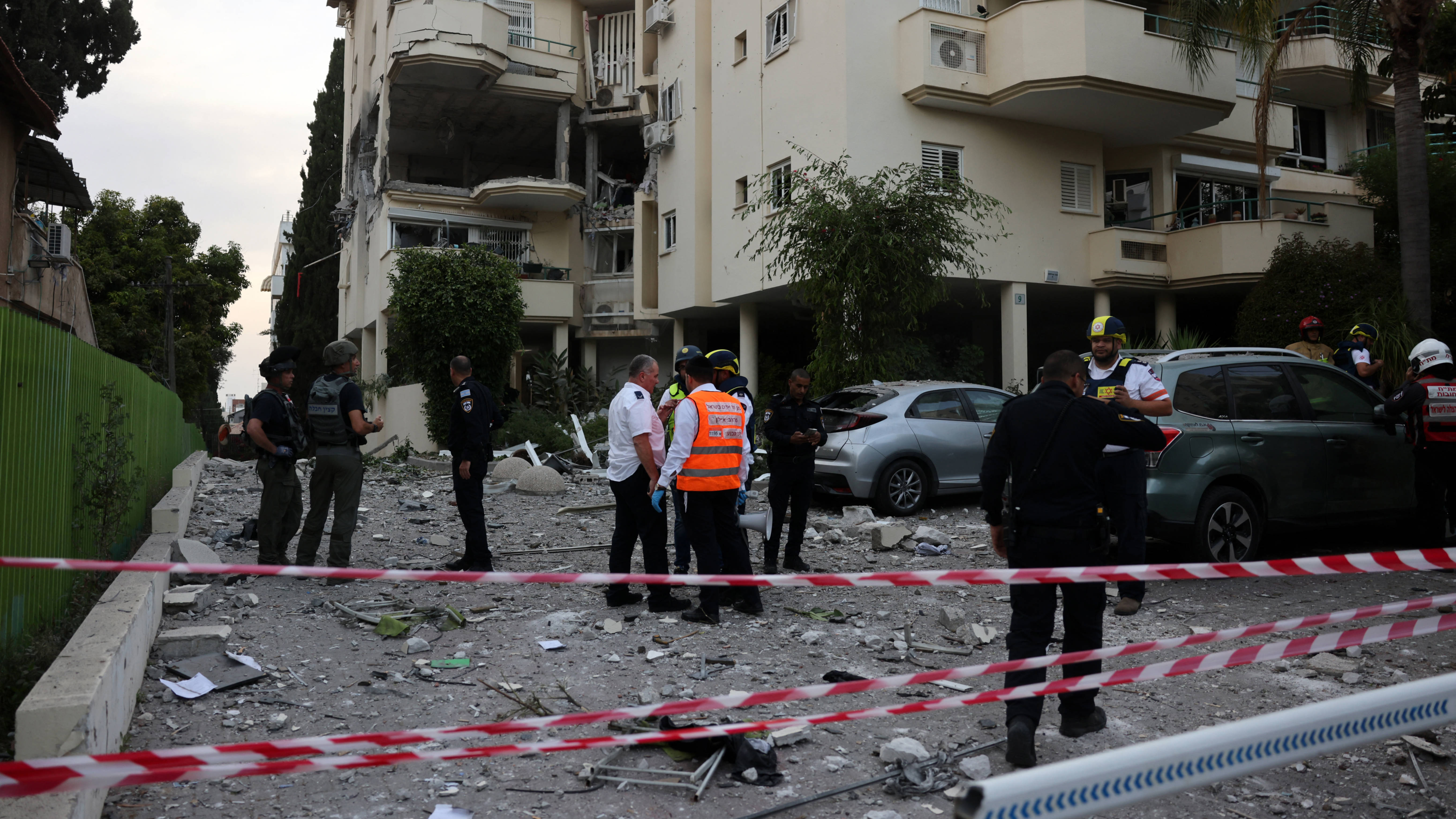 Israeli forces and rescuers secure the area near a building hit by a rocket fired from the Gaza strip, in Rehovot near Tel Aviv, on 11 May 2023 (AFP)