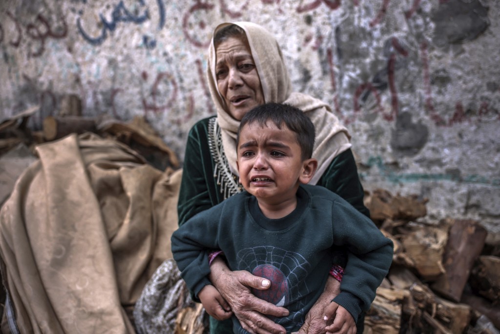 A child and a woman react following an Israeli air strike in Beit Lahia in the northern Gaza Strip, on May 13, 2023.