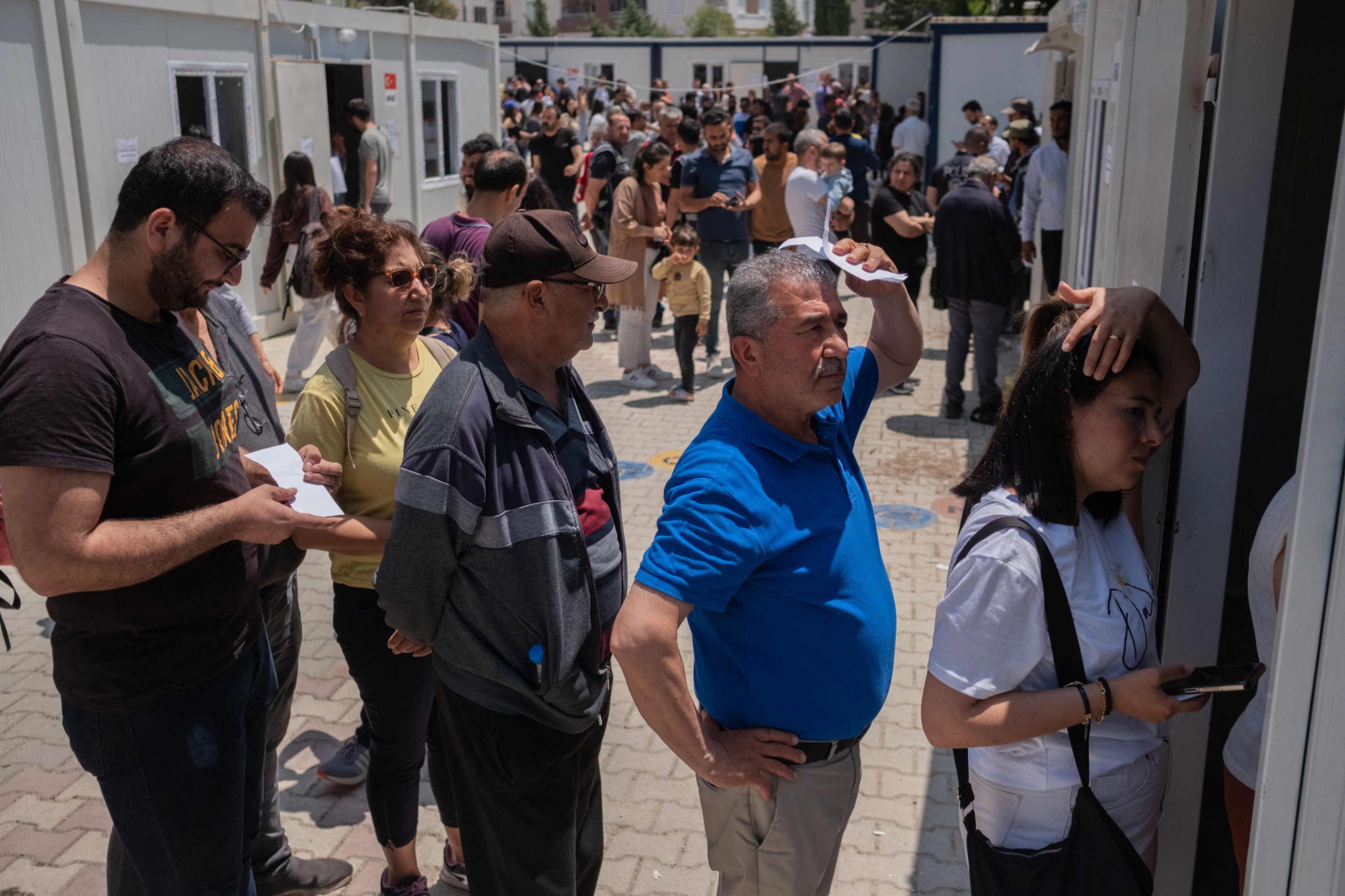 People queue to vote outside containers acting as improvised polling stations during the presidential and parliamentary elections in the southern Turkish city of Antakya (AFP)