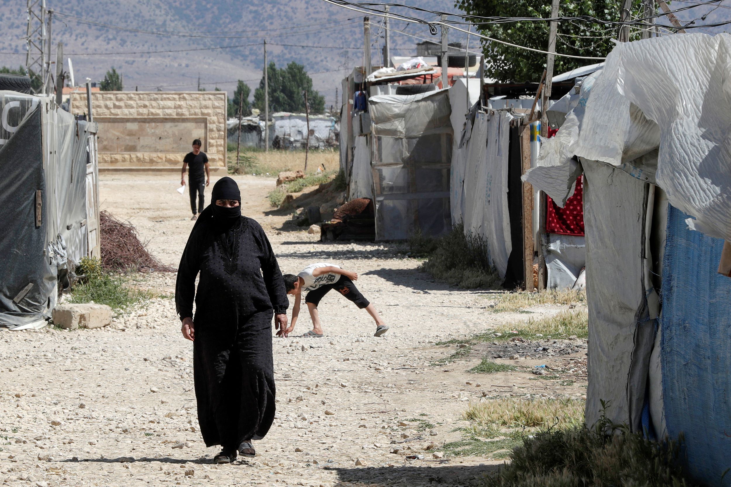Une Syrienne marche entre les tentes d’un camp de réfugiés à Saadnayel, dans la vallée de la Bekaa, dans l’est du Liban, le 13 juin 2023 (AFP)