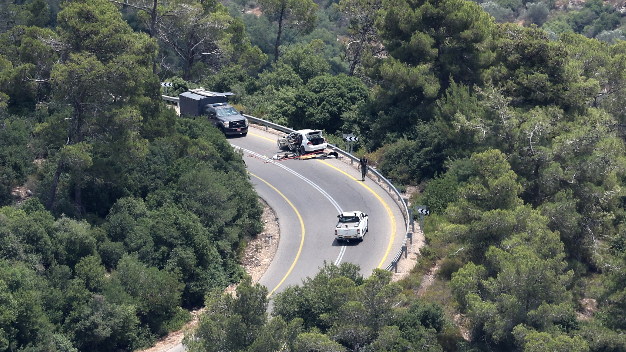 Israeli forces gather around the body of Palestinian man after killing him near Deir Nidham village, northwest of the occupied West Bank city of Ramallah on 10 July 2023 (AFP)